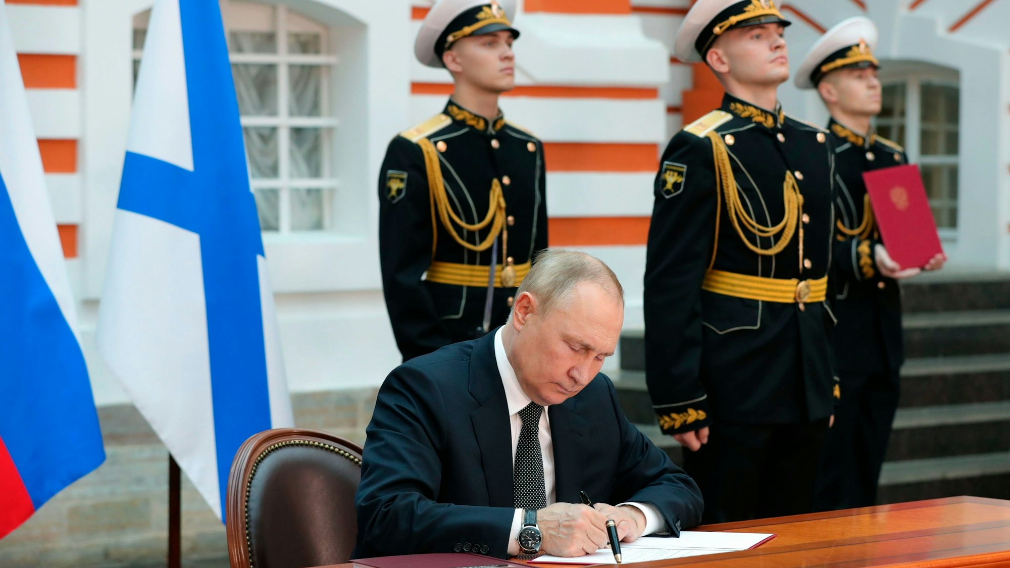 Wladimir Putin (l.), Präsident von Russland, unterzeichnet die Dekrete zur Verabschiedung der Marinedoktrin und der Schiffscharta der russischen Marine im Staatlichen Historischen Museum in der Peter-und-Paul-Festung in St. Petersburg vor der großen Marine-Parade zum Tag der russischen Marine am Sonntag (31. Juli).