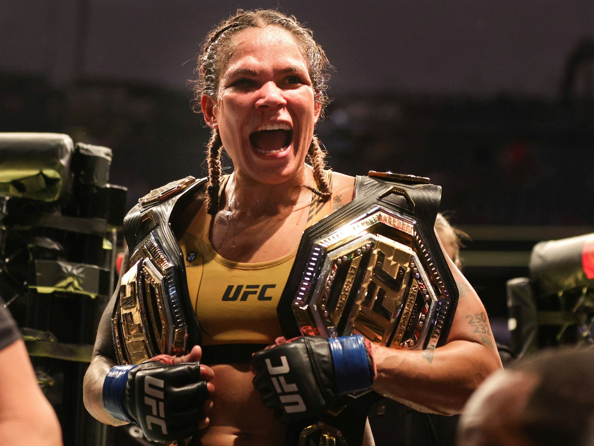 Amanda Nunes im Ring mit zwei WM-Gürtel der UFC.