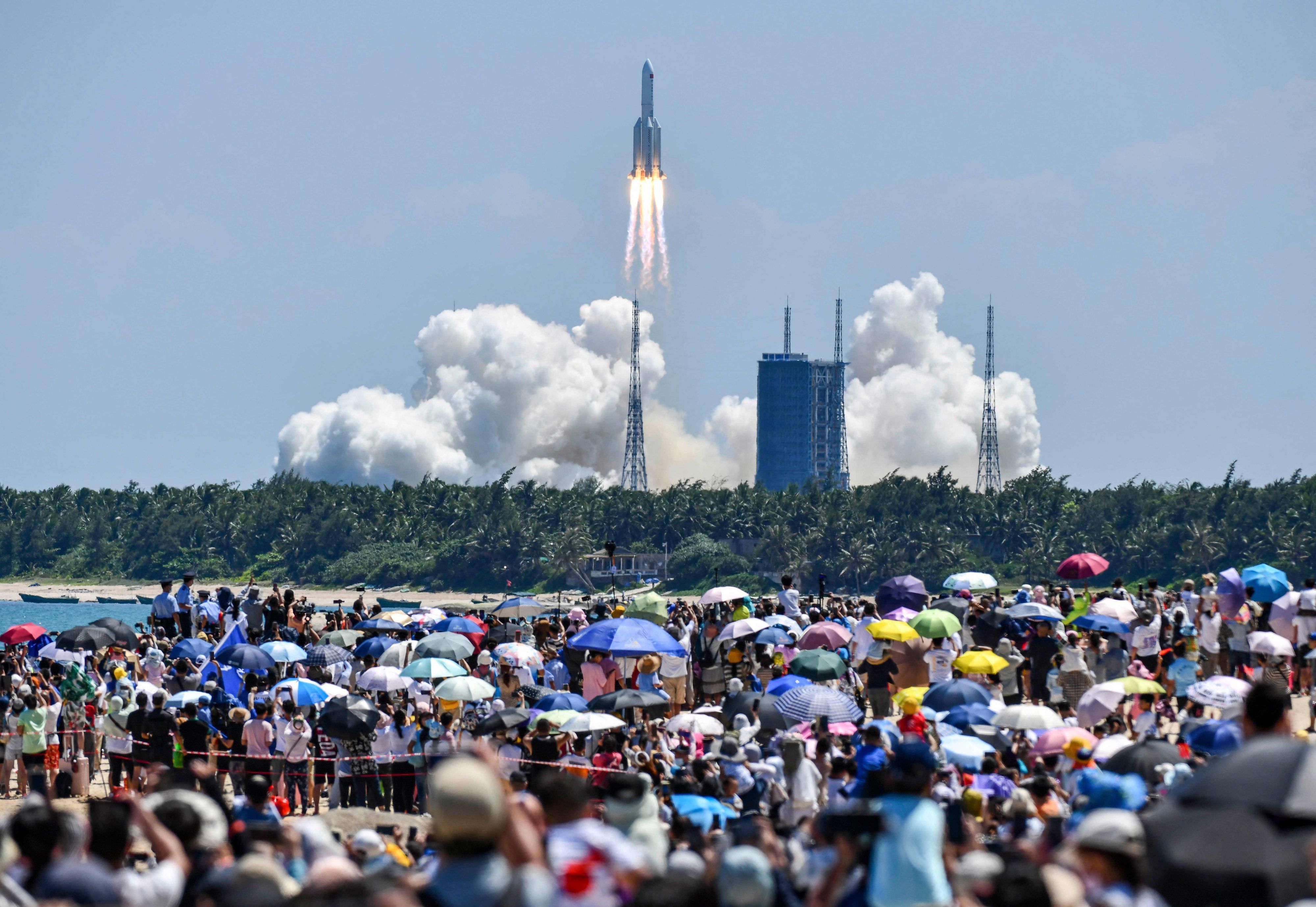 Menschen schauen am 24. Juli in China dabei zu, wie eine Rakete mit einem Modul für die chinesische Raumstation startet. Eine Rakete ist am Samstag aus dem Weltraum kommend in die Erdatmosphäre eingetreten.