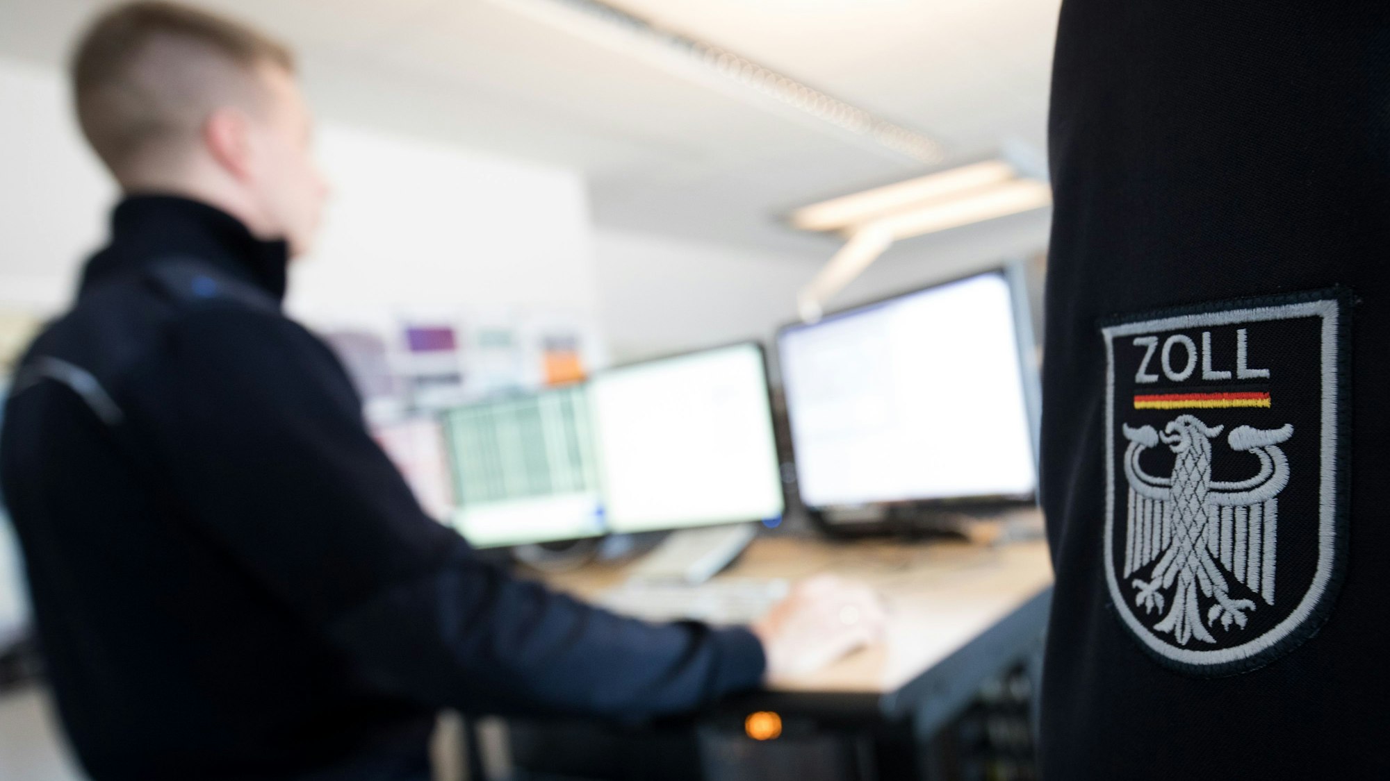 Ein Zollbeamter prüft an einem Computer die Ladung eines Containers in der Container Röntgenanlage am Zollamt Waltershof.
