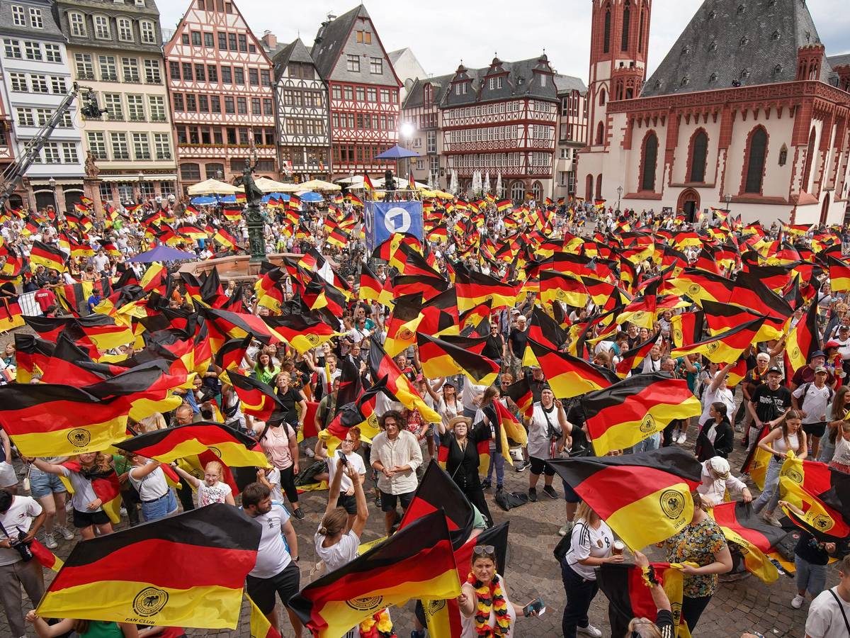 Zahlreiche Fans schwenken Deutschland-Flaggen beim Empfang der DFB-Auswahl in Frankfurt.