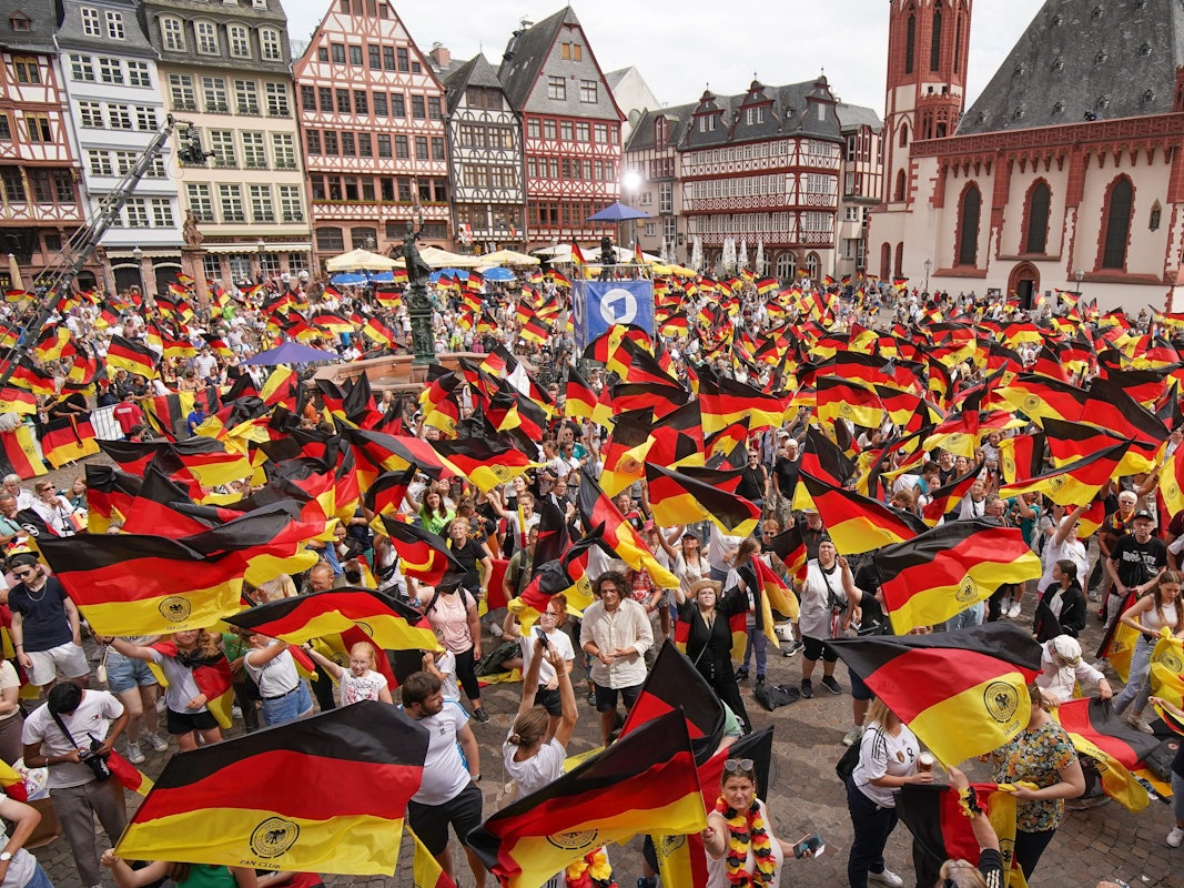 Zahlreiche Fans schwenken Deutschland-Flaggen beim Empfang der DFB-Auswahl in Frankfurt.