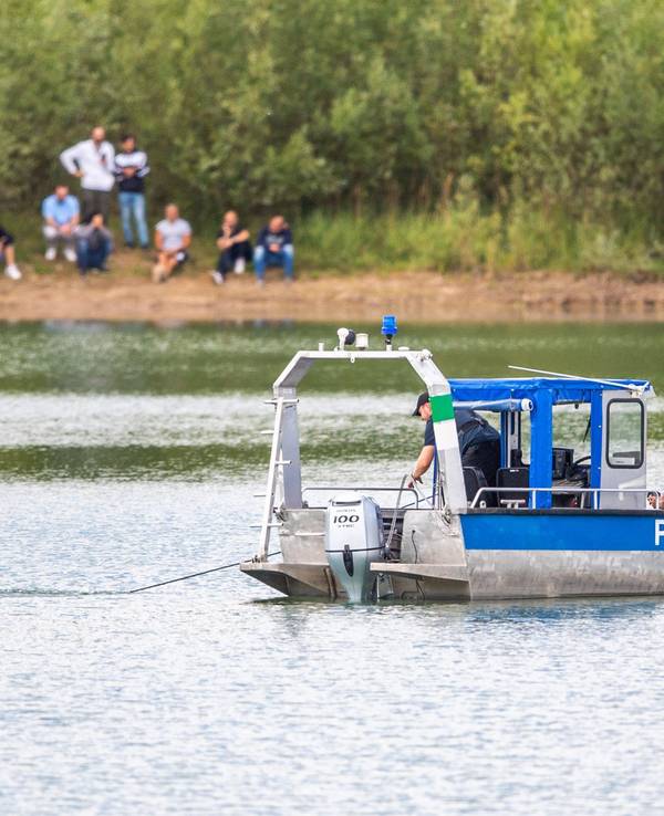 Ein Polizeiboot mit Tauchern der Taucheinheit Bochum ist auf einem Kiesteich in Porta Westfalica im Einsatz, an dem am Sonntag (24.07.2022) aus ungeklärten Gründen beim Baden zwei Personen nicht mehr aufgetaucht sind.