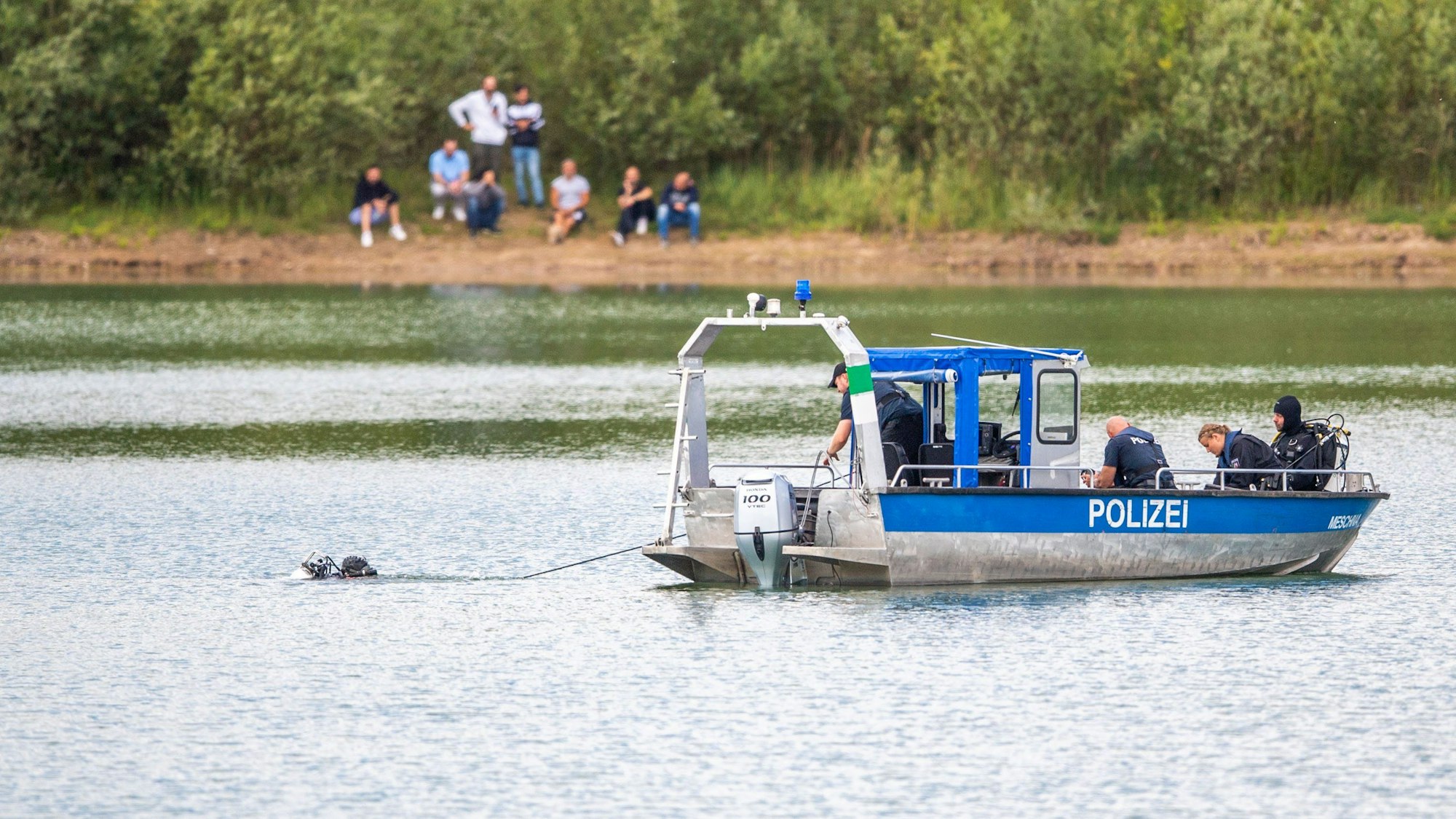 Ein Polizeiboot mit Tauchern der Taucheinheit Bochum ist auf einem Kiesteich in Porta Westfalica im Einsatz, an dem am Sonntag (24.07.2022) aus ungeklärten Gründen beim Baden zwei Personen nicht mehr aufgetaucht sind.