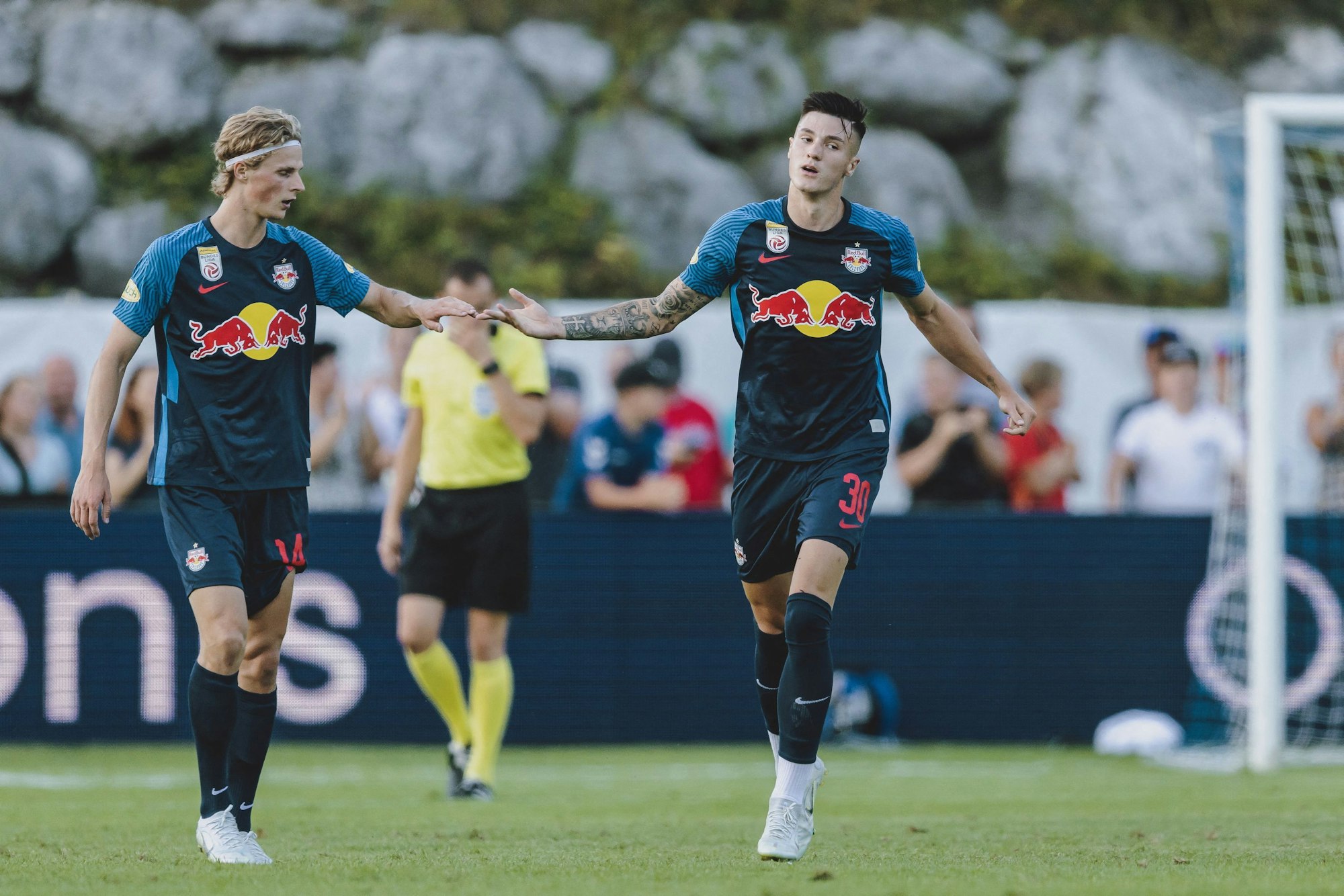 Benjamin Sesko (RB Salzburg) klatscht sich mit Maurits Kjaergaard ab.