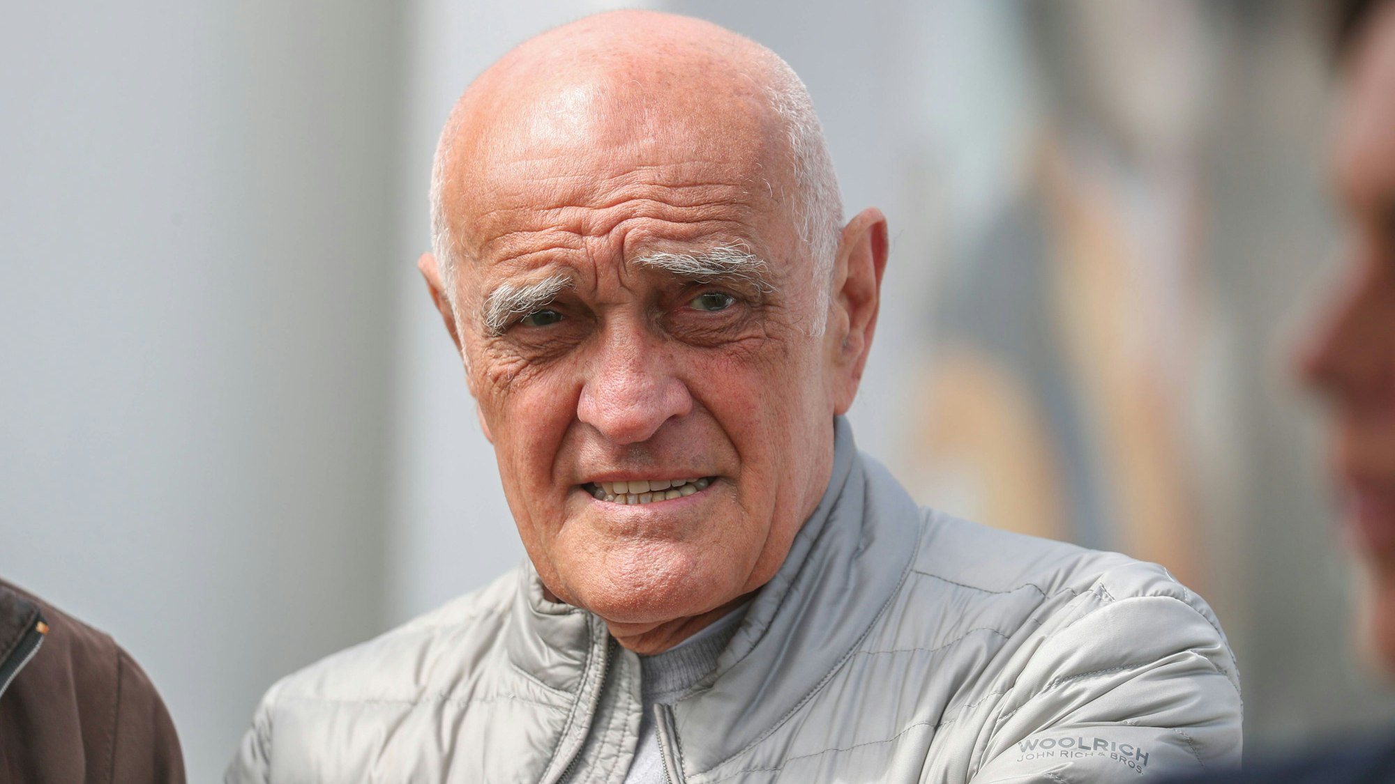 Martin Kind steht bei einer Galopprennbahn auf den Zuschauerrängen.