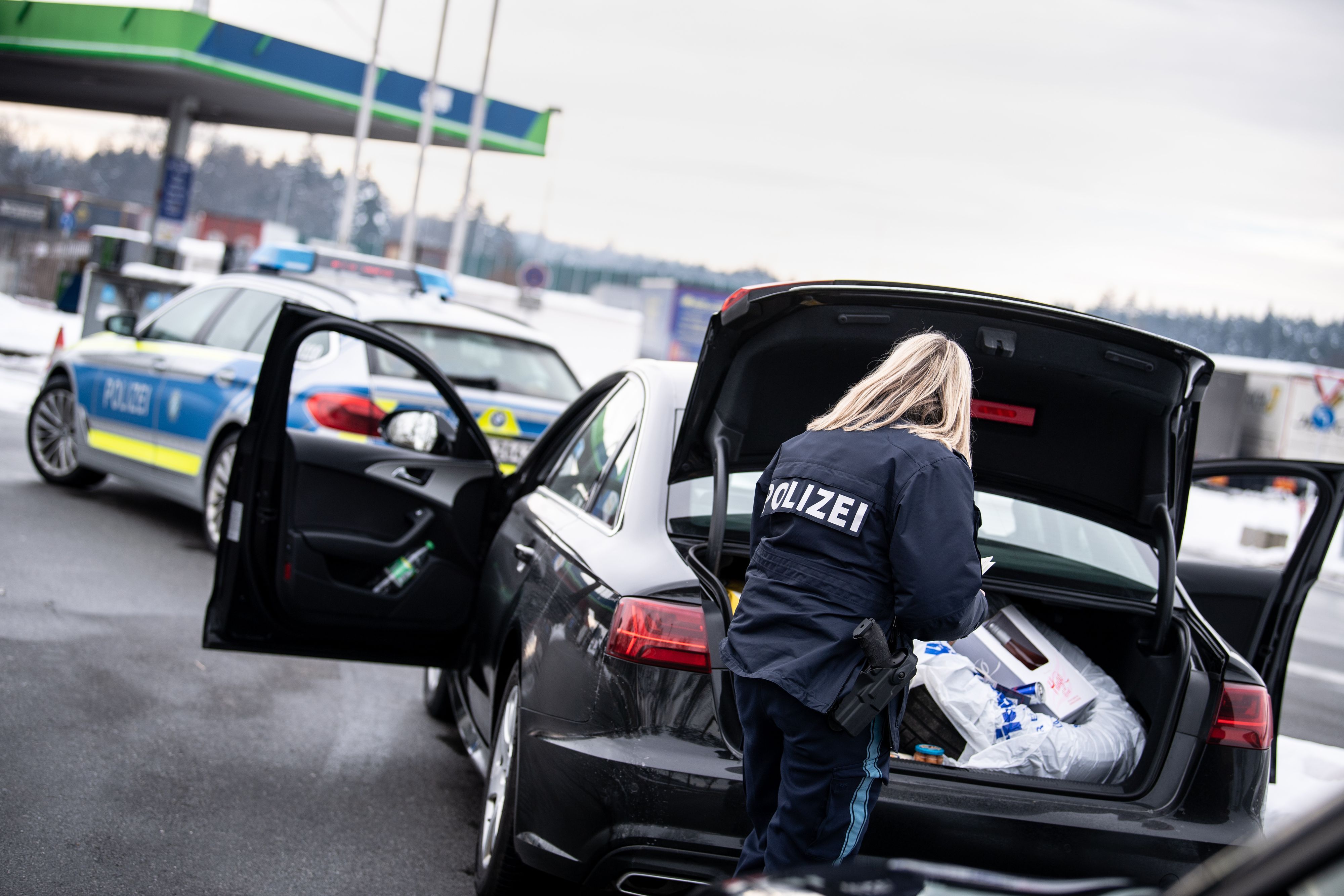Eine Polizistin der Bayerischen Grenzpolizei kontrolliert auf einem Rastplatz auf der Autobahn 3 vor der österreichischen Grenze ein Fahrzeug.