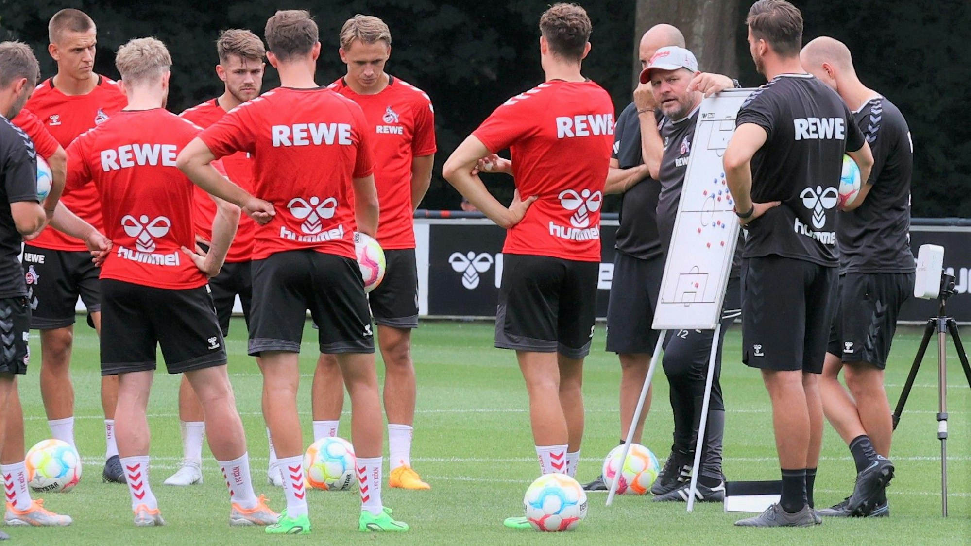 Steffen Baumgart spricht im Training des 1. FC Köln an einer Taktik-Tafel mit seiner Mannschaft