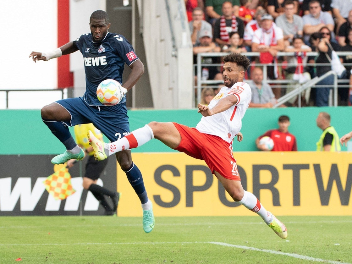 Anthony Modeste (l) vom 1. FC Köln und Leon Guwara vom SSV Jahn Regensburg im Zweikampf um den Ball.