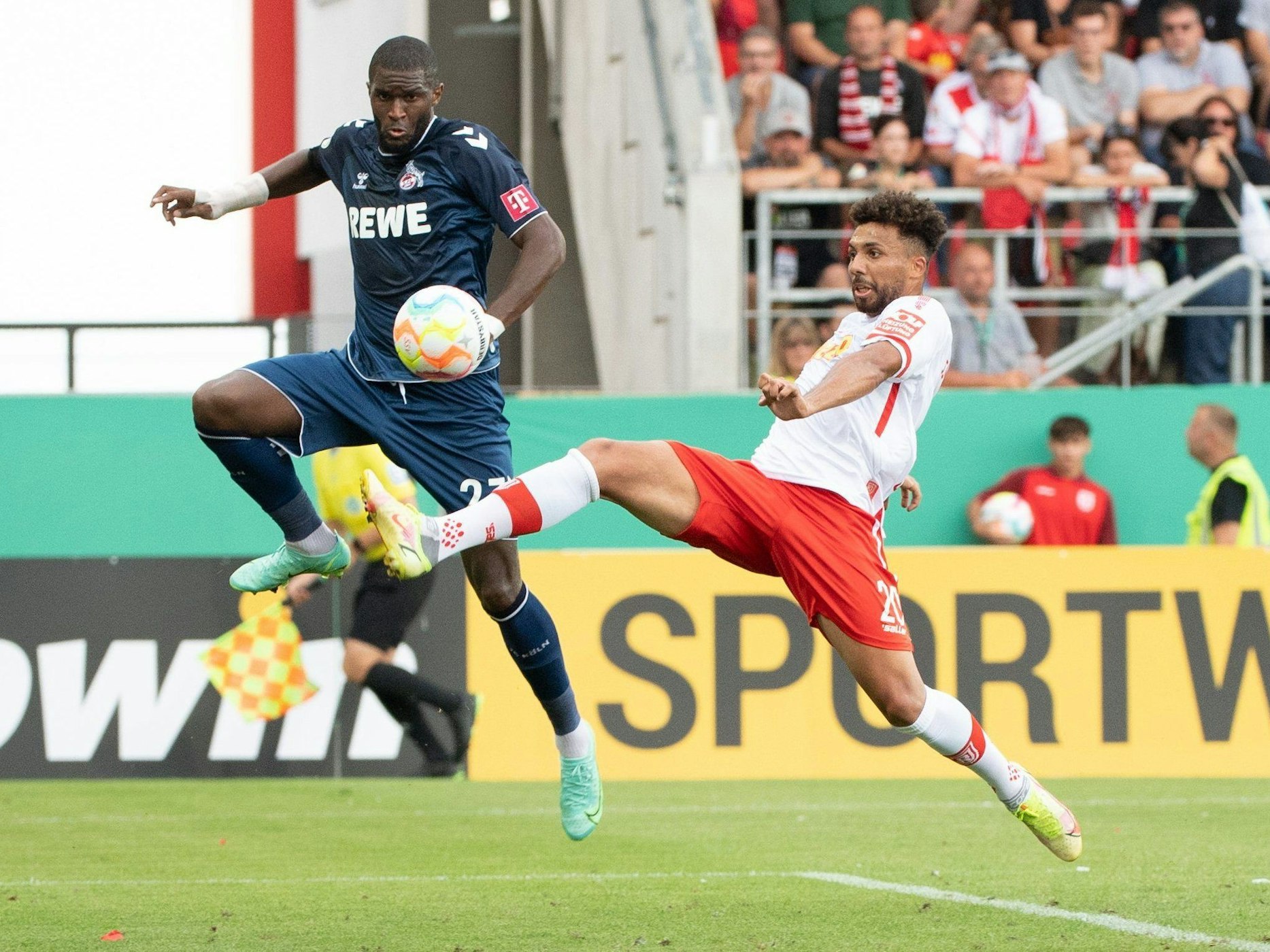 Anthony Modeste (l) vom 1. FC Köln und Leon Guwara vom SSV Jahn Regensburg im Zweikampf um den Ball.
