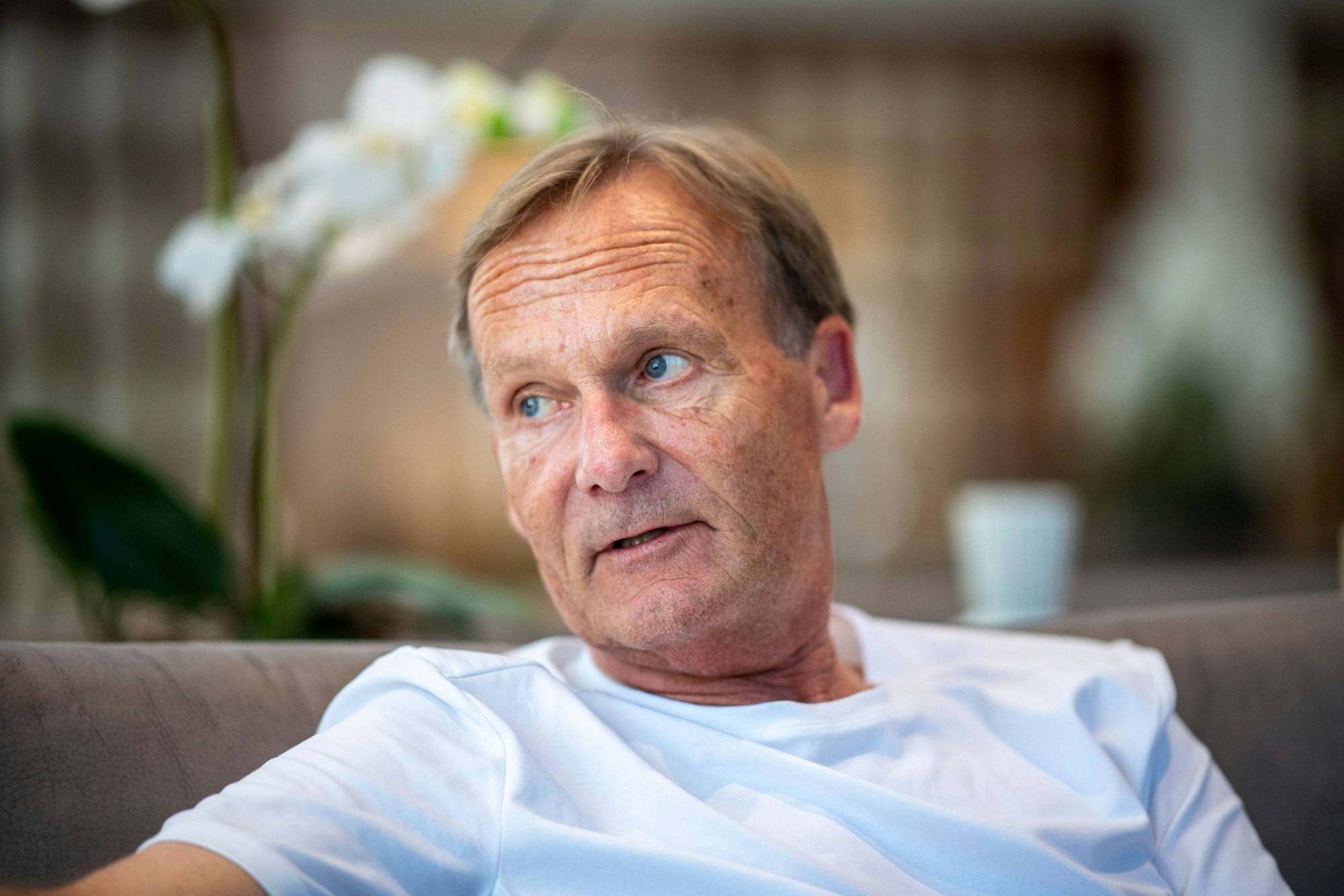 Hans-Joachim Watzke sitzt auf einem Sofa.
