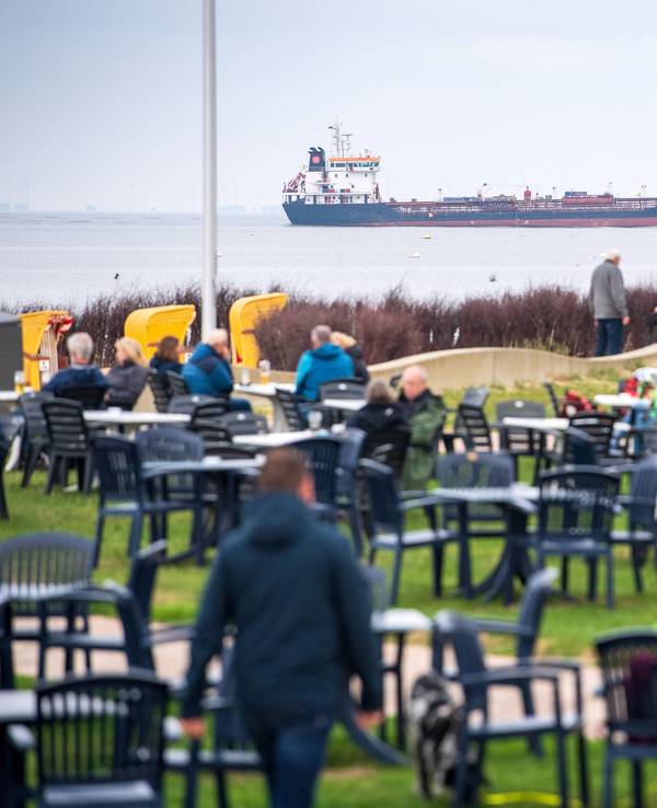 Ein Café macht an der Nordsee derzeit mit seiner knallharten Kinder-Maßnahme von sich reden. Urlauber sitzen in unserem Symbolbild (2021) vor einem Café am Strand von Cuxhaven. Es handelt sich hier nicht um das betroffene Café.