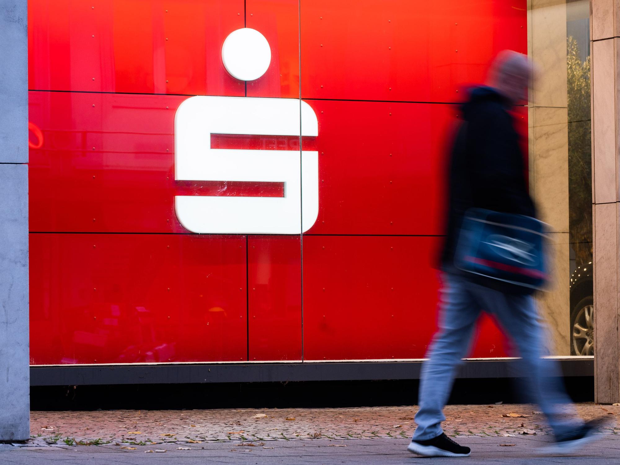 Ein Fußgänger läuft an einer Filiale der Sparkasse vorbei. Ein beliebter Service wird in Kürze abgeschafft.
