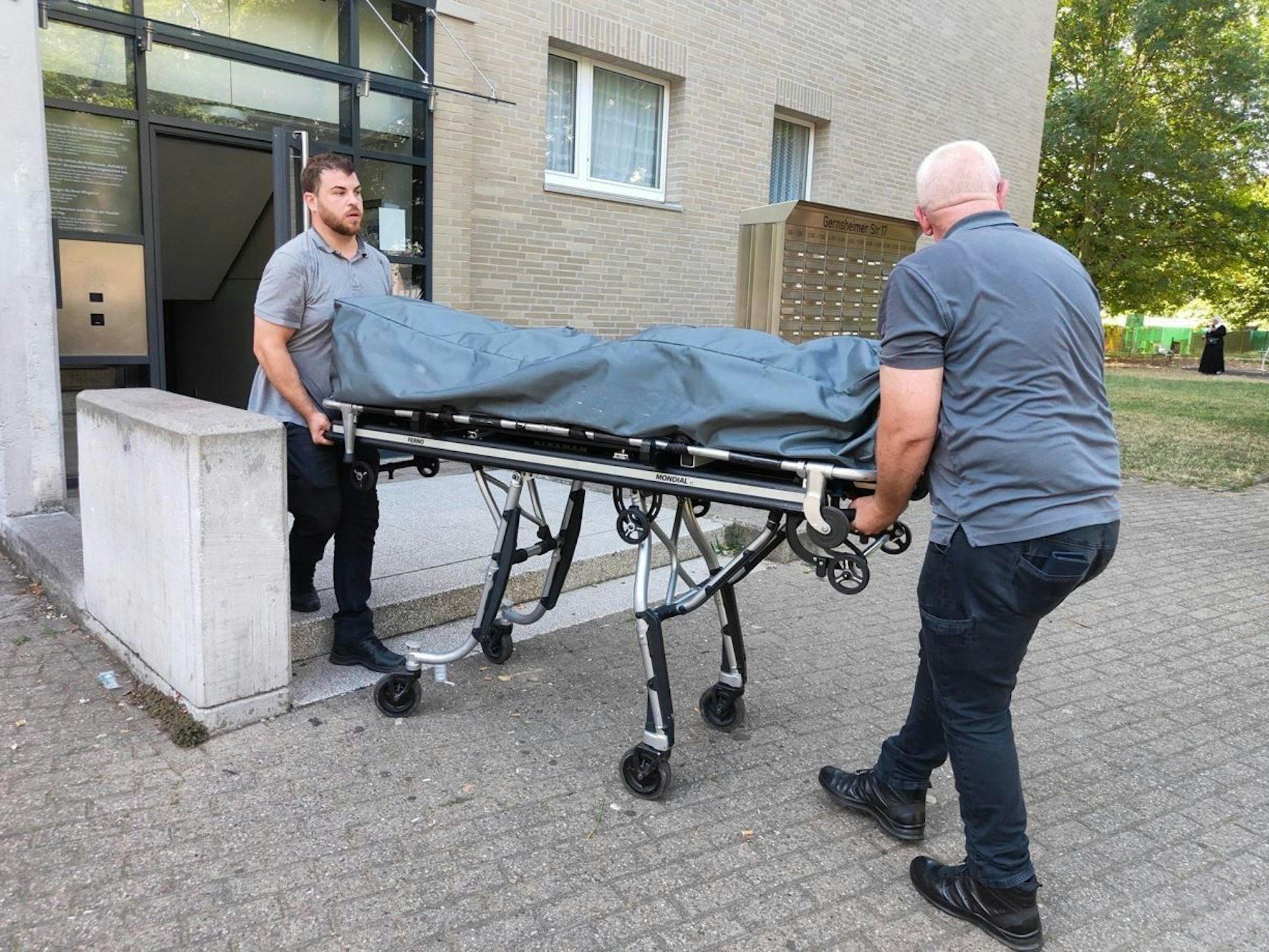 Helfer fahren Leiche von einem Tatort. In Köln-Ostheim ist ein Mann bei einer Räumung seiner Wohnung erschossen worden.