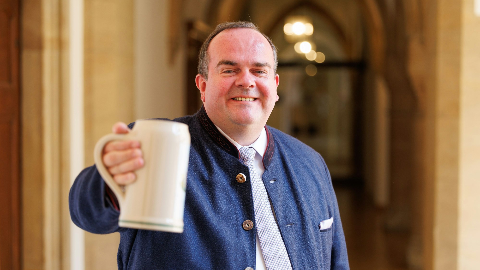 Clemens Baumgärtner hält einen Maßkrug in den Händen.