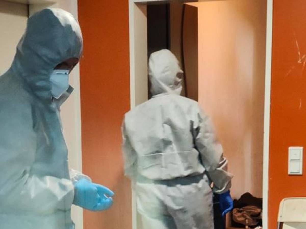 In Ganzkörperanzügen sichern zwei Kräfte der Polizei Spuren an einer Wohnung.