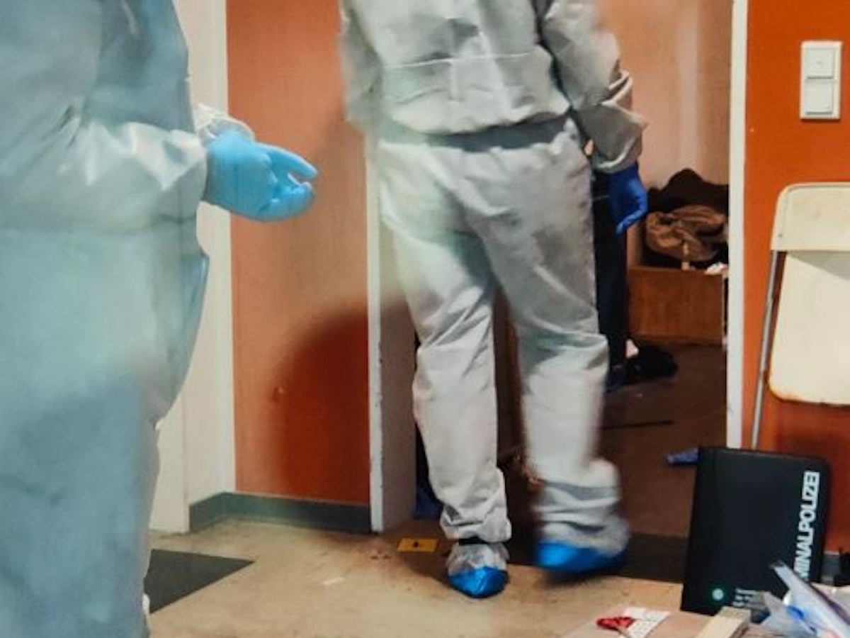 In Ganzkörperanzügen sichern zwei Kräfte der Polizei Spuren an einer Wohnung.