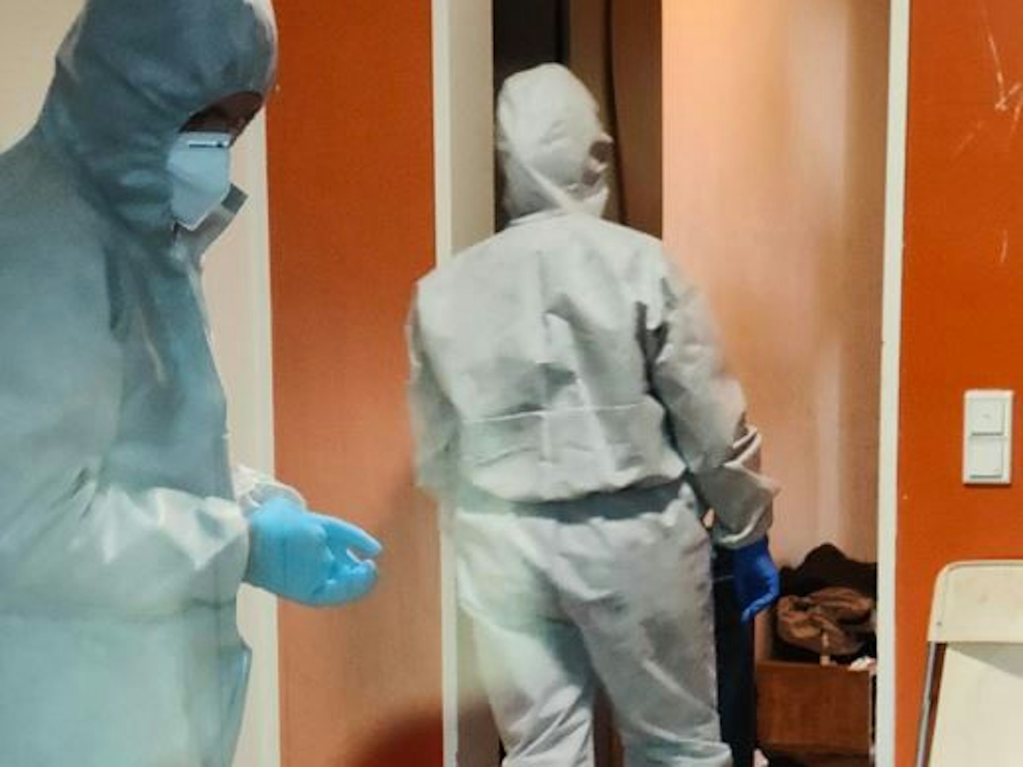 In Ganzkörperanzügen sichern zwei Kräfte der Polizei Spuren an einer Wohnung.