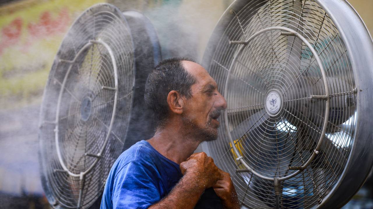 Ein Mann kühlt sich vor einem Ventilator ab, während im Irak eine Hitzewelle herrscht