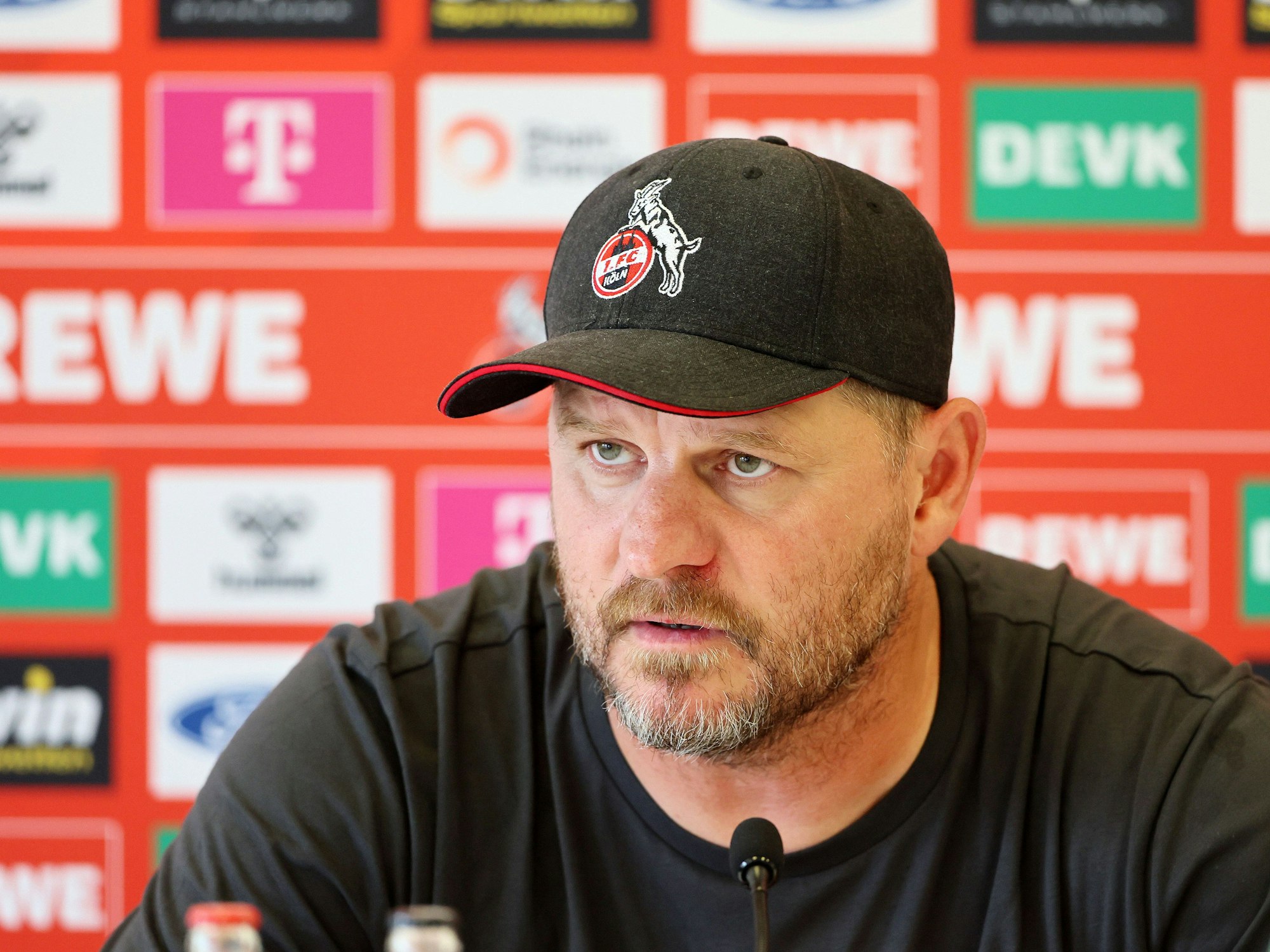 Steffen Baumgart sitzt bei der Pressekonferenz vor einem Mikrofon.