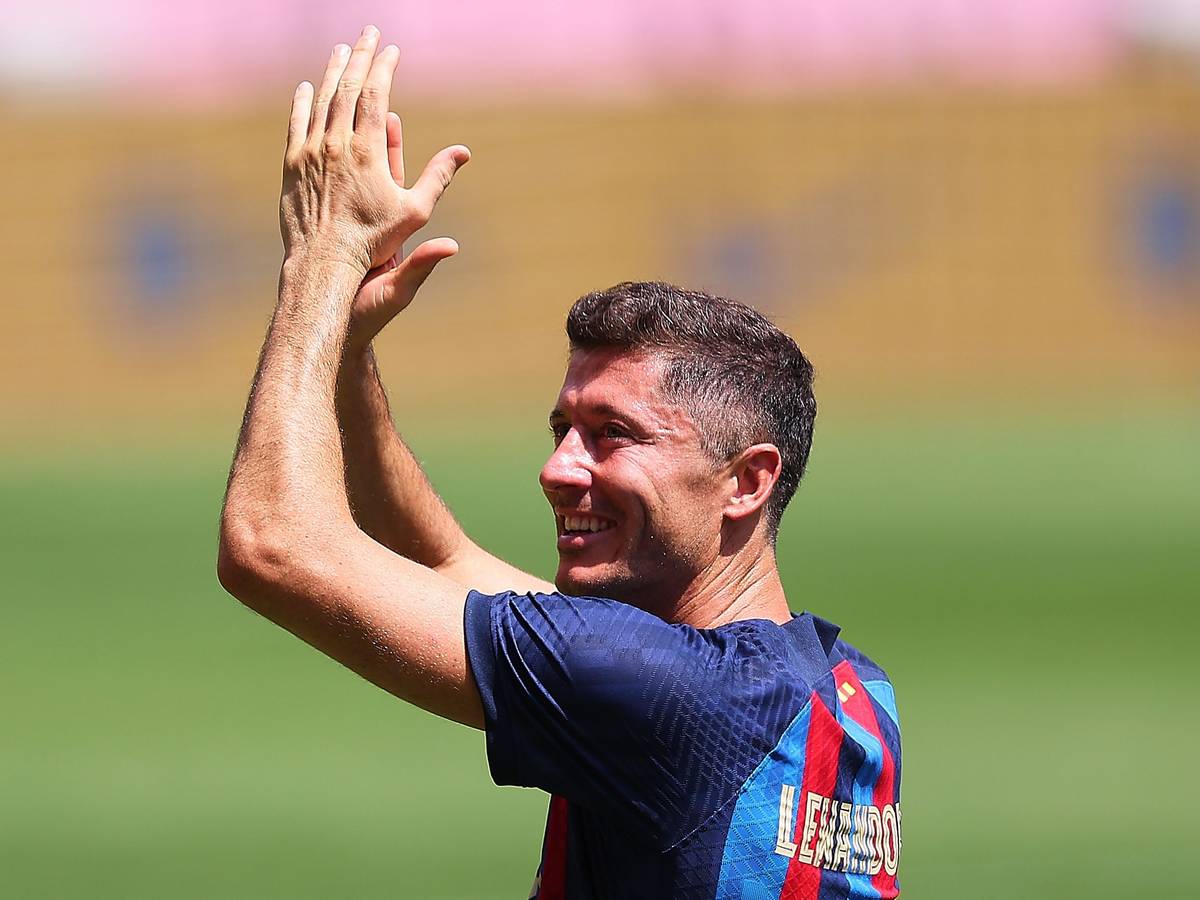 Robert Lewandowski klatscht bei seiner Vorstellung im Trikot des FC Barcelona im Camp Nou über dem Kopf in die Hände