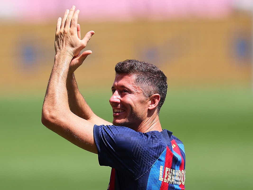 Robert Lewandowski klatscht bei seiner Vorstellung im Trikot des FC Barcelona im Camp Nou über dem Kopf in die Hände