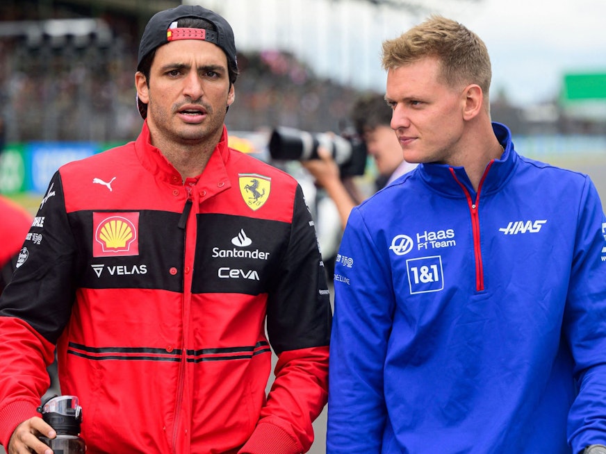 Mick Schumacher geht beim Renn-Wochenende der Formel 1 mit Ferrari-Pilot Carlos Sainz durch die Boxengasse.