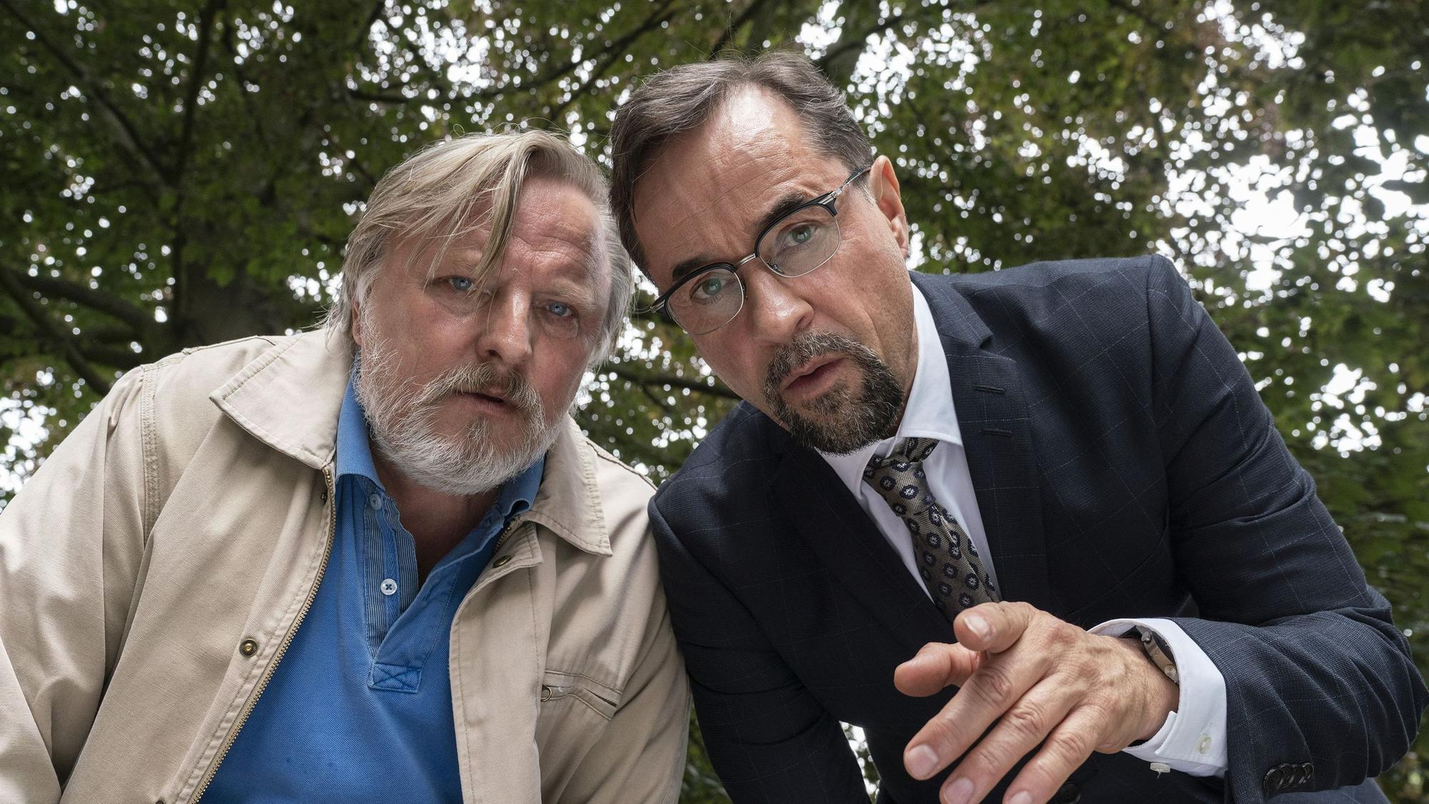 Axel Prahl und Jan Losef Liefers beugen sich in einer „Tatort“-Szene nach vorne.