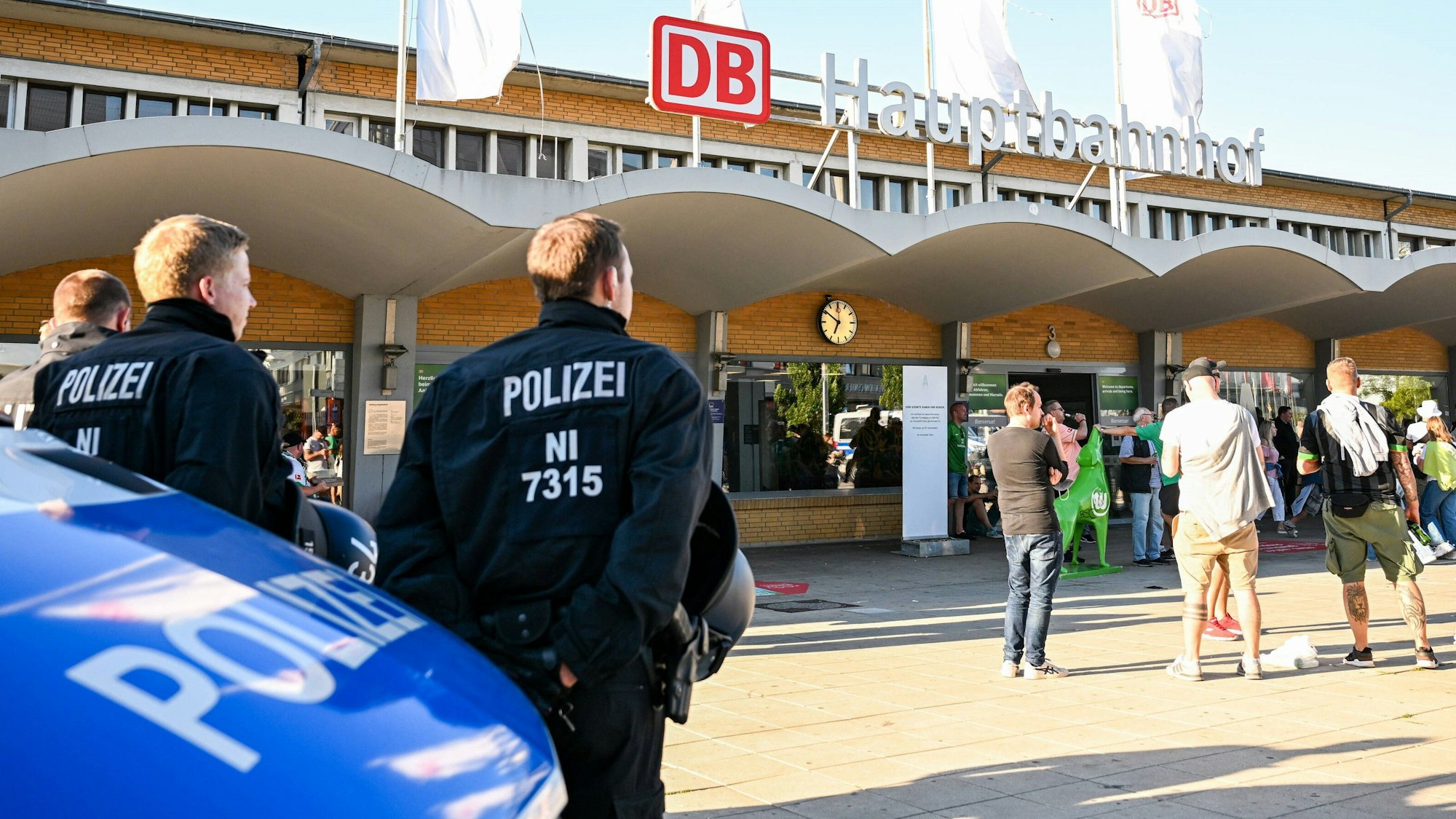 Polizisten stehen vor dem Hauptbahnhof in Wolfsburg und beobachten Fans von Werder Bremen