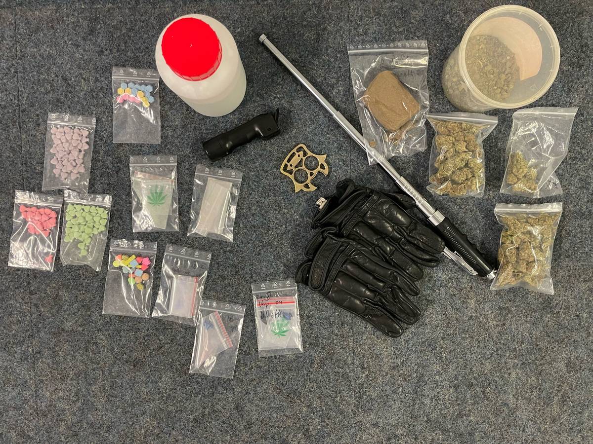 In kleinen Tütchen befinden sich diverse Drogen, dazwischen liegen Waffen wie ein Teleskopschlagstock.