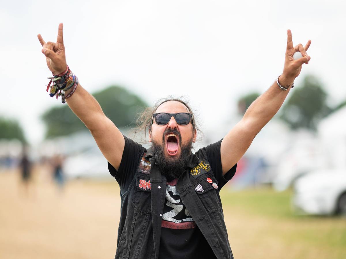 Ein Festivalbesucher feiert auf dem Campingplatz des Wacken Open Air Festivals 2022.