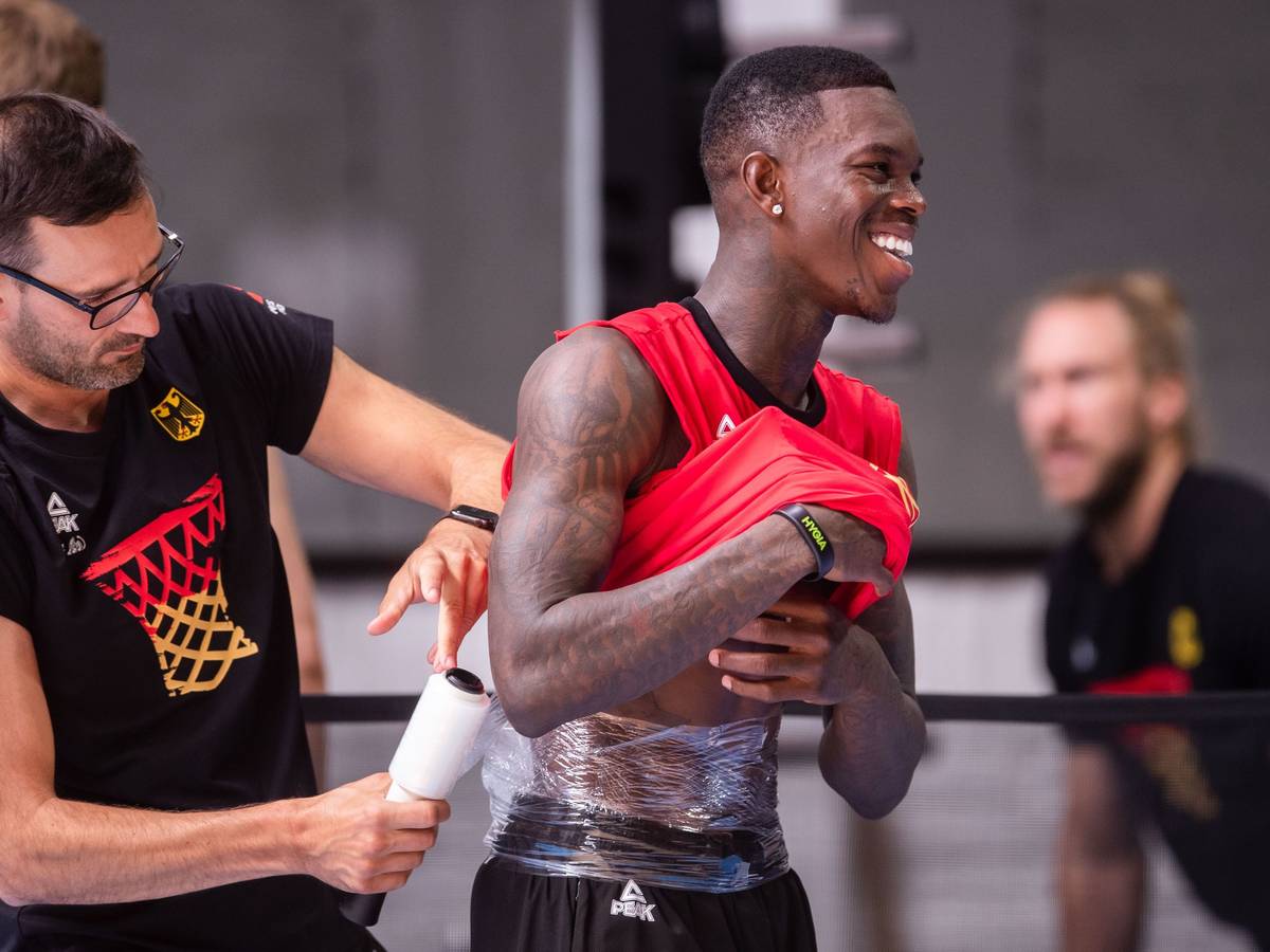 Dennis Schröder (r) lässt sich nach dem Training der Basketball-Nationalmannschaft einen Eisbeutel am Rücken befestigen. Die Mannschaft bereitet sich auf die Europameisterschaft vor, die im September ausgetragen wird.