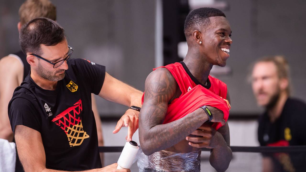 Dennis Schröder (r) lässt sich nach dem Training der Basketball-Nationalmannschaft einen Eisbeutel am Rücken befestigen. Die Mannschaft bereitet sich auf die Europameisterschaft vor, die im September ausgetragen wird.