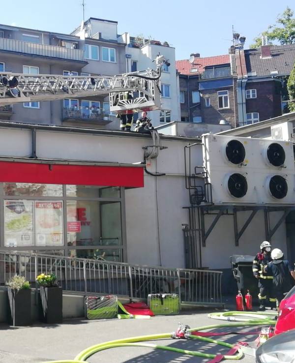 Einsatzkräfte der Feuerwehr löschen den Brand in einem Rewe-Markt in der Kölner Südstadt.
