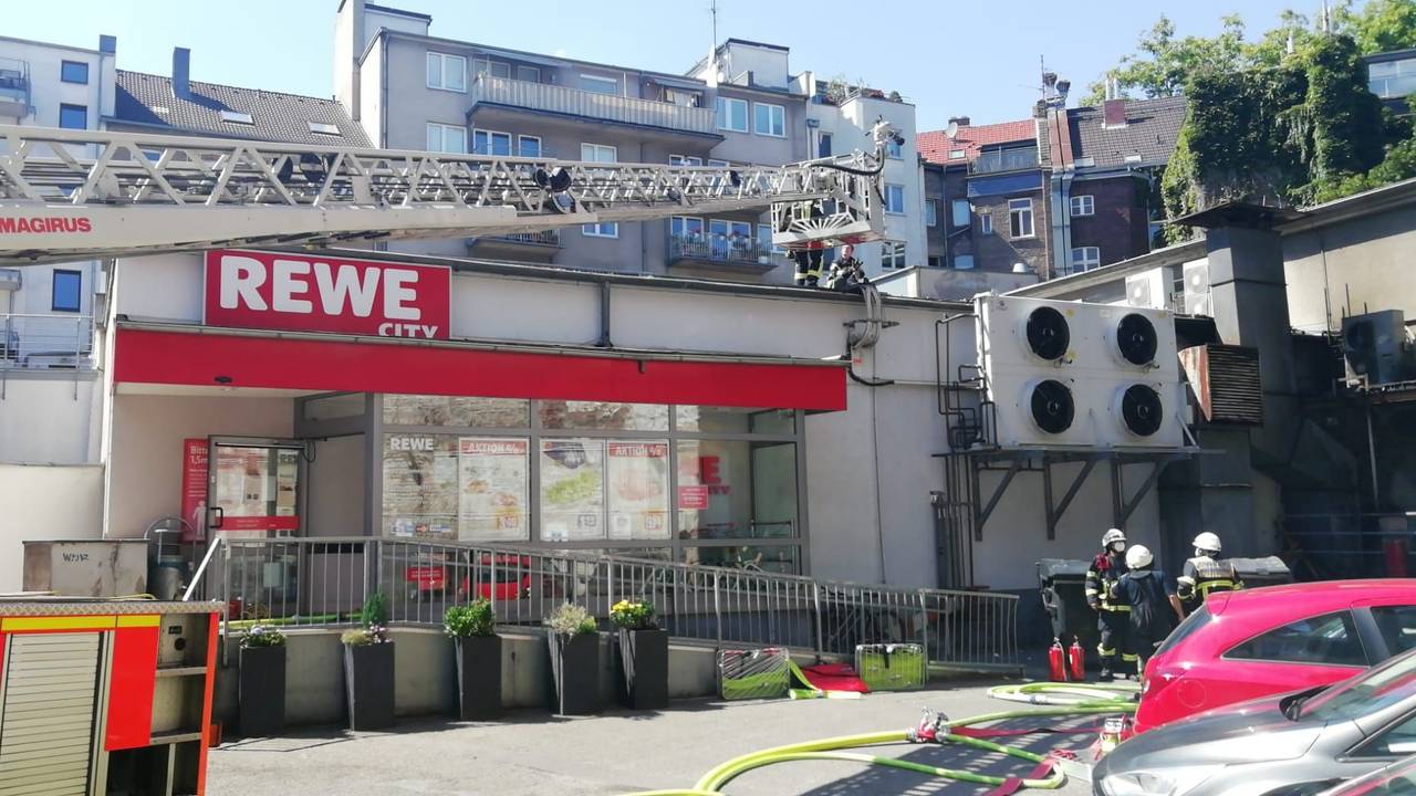 Einsatzkräfte der Feuerwehr löschen den Brand in einem Rewe-Markt in der Kölner Südstadt.