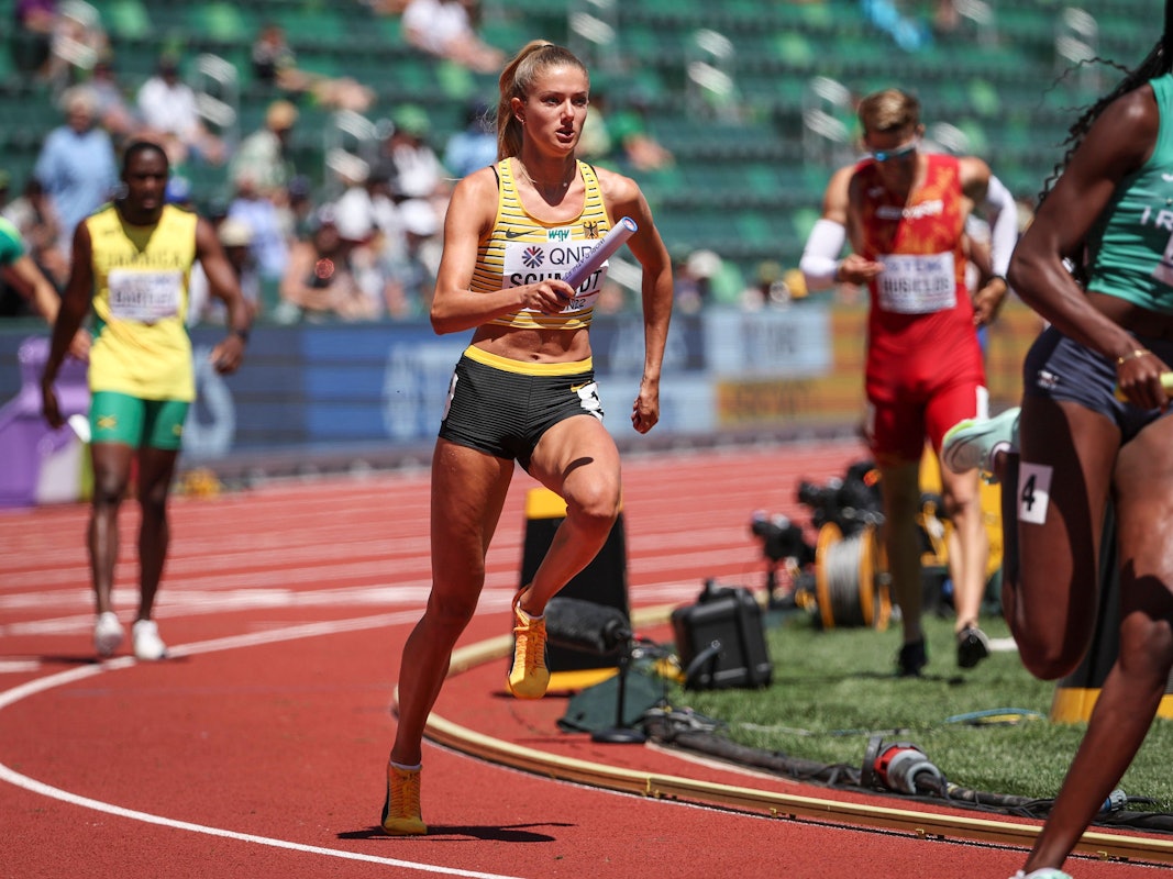 Alica Schmidt läuft mit einem Staffelstab in der Hand.