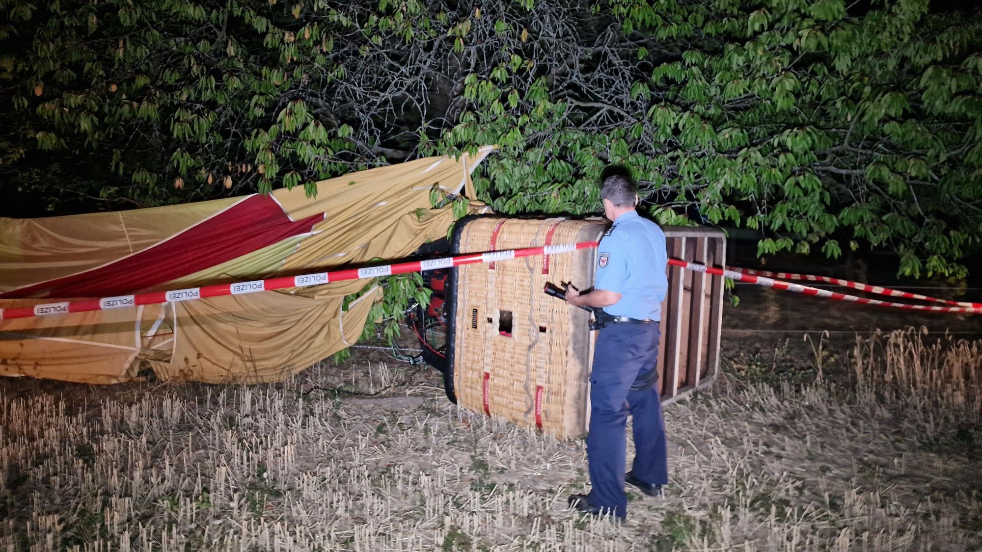 Ein Polizist inspiziert einen verunfallten Heißluftballon. Bei einem Unfall mit einem Heißluftballon ist am Montagabend ein Mann in Beelitz (Landkreis Potsdam-Mittelmark) ums Leben gekommen.