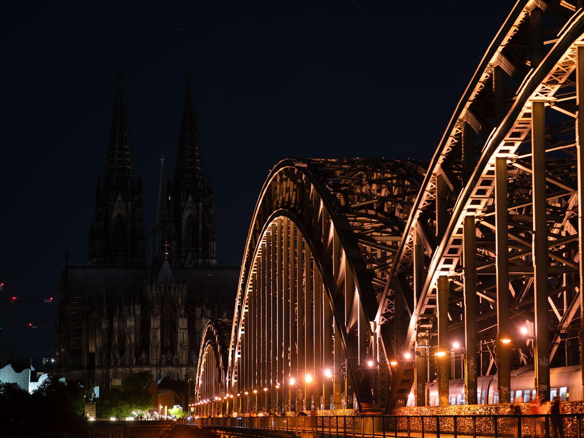 Unbeleuchtet ist der Kölner Dom nach 23 Uhr. Im Vordergrund die Hohenzollernbrücke.