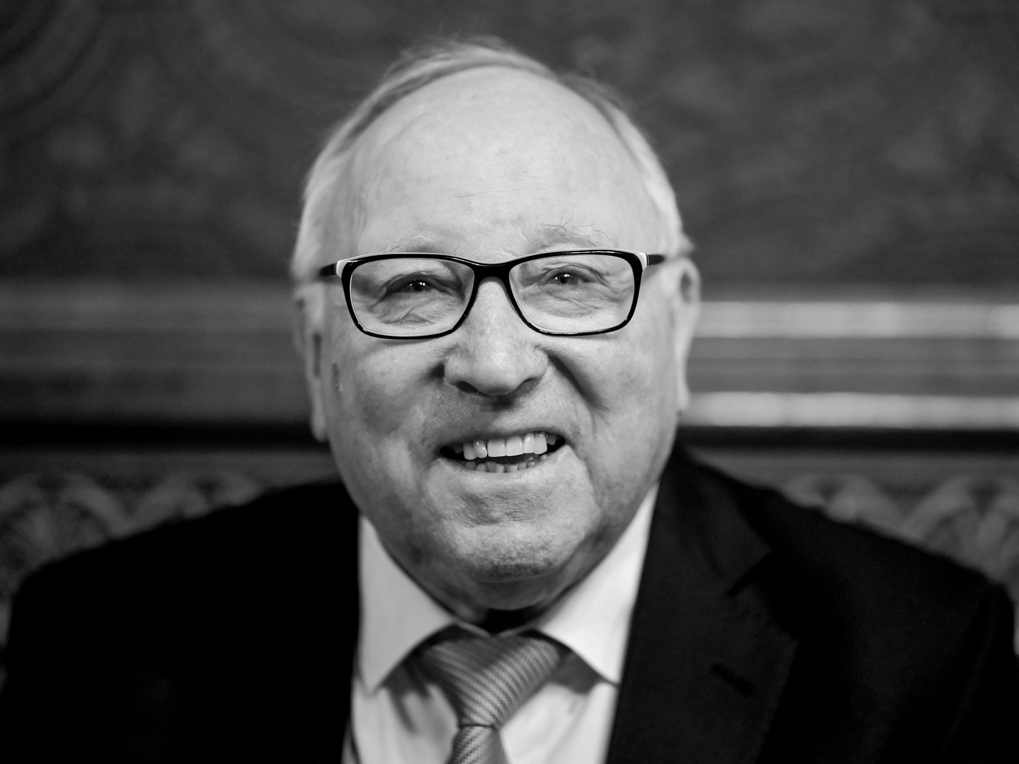 Die Schwarz-Weiß-Aufnahme zeigt Uwe Seeler, der in die Kamera lächelt.