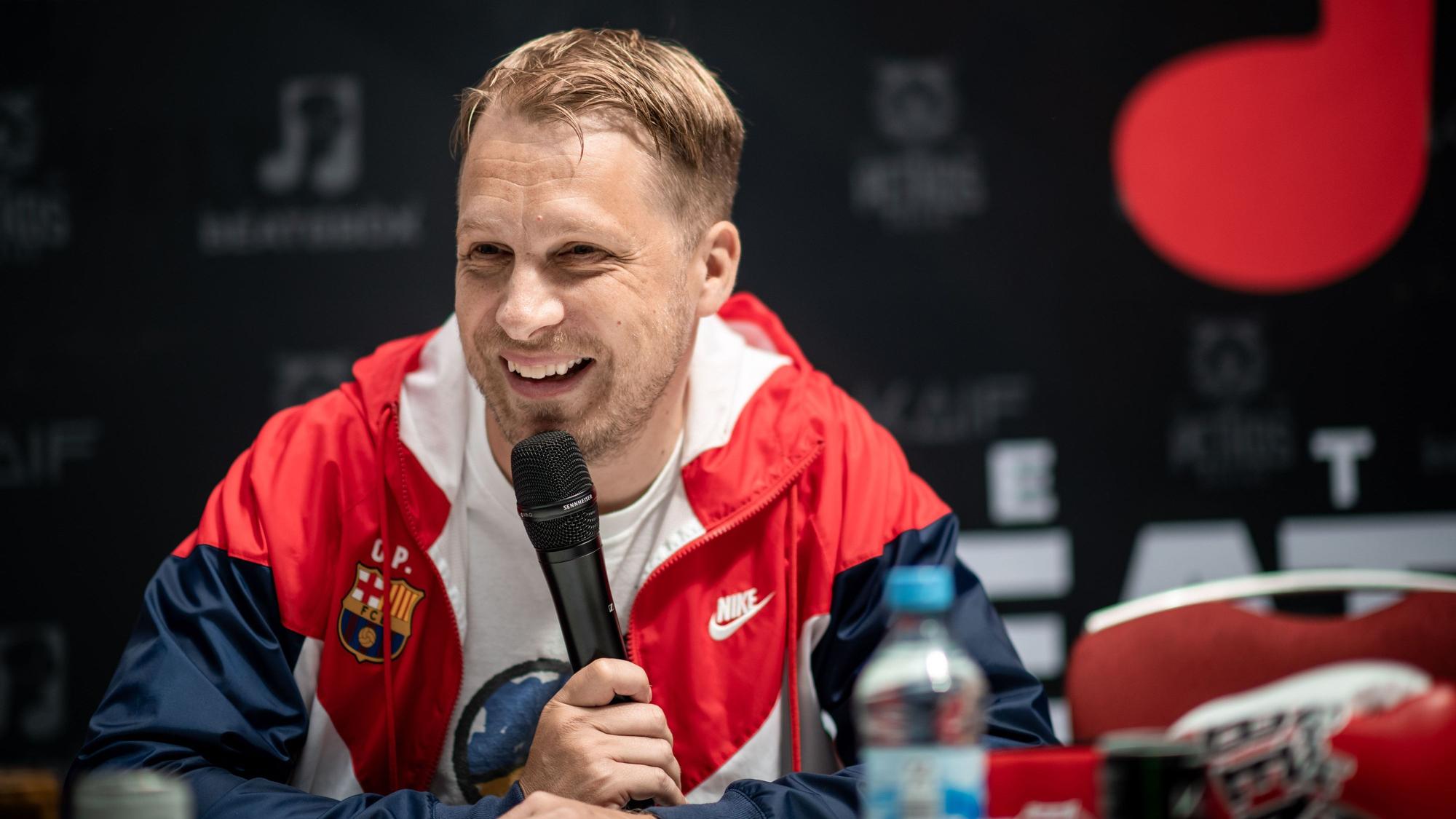 Oliver Pocher sitzt bei der Pressekonferenz im Westfield Centro in Oberhausen auf einer Bühne.