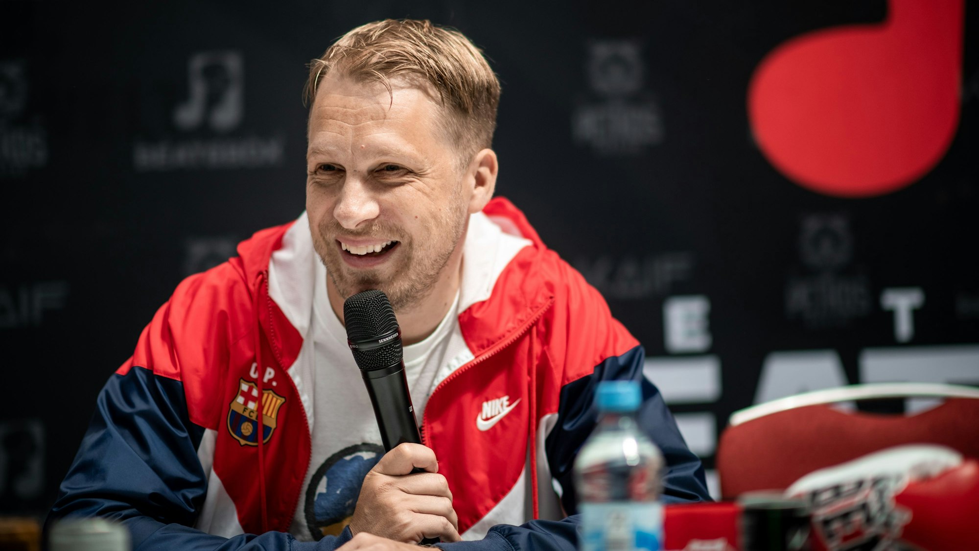 Oliver Pocher sitzt bei der Pressekonferenz im Westfield Centro in Oberhausen auf einer Bühne.