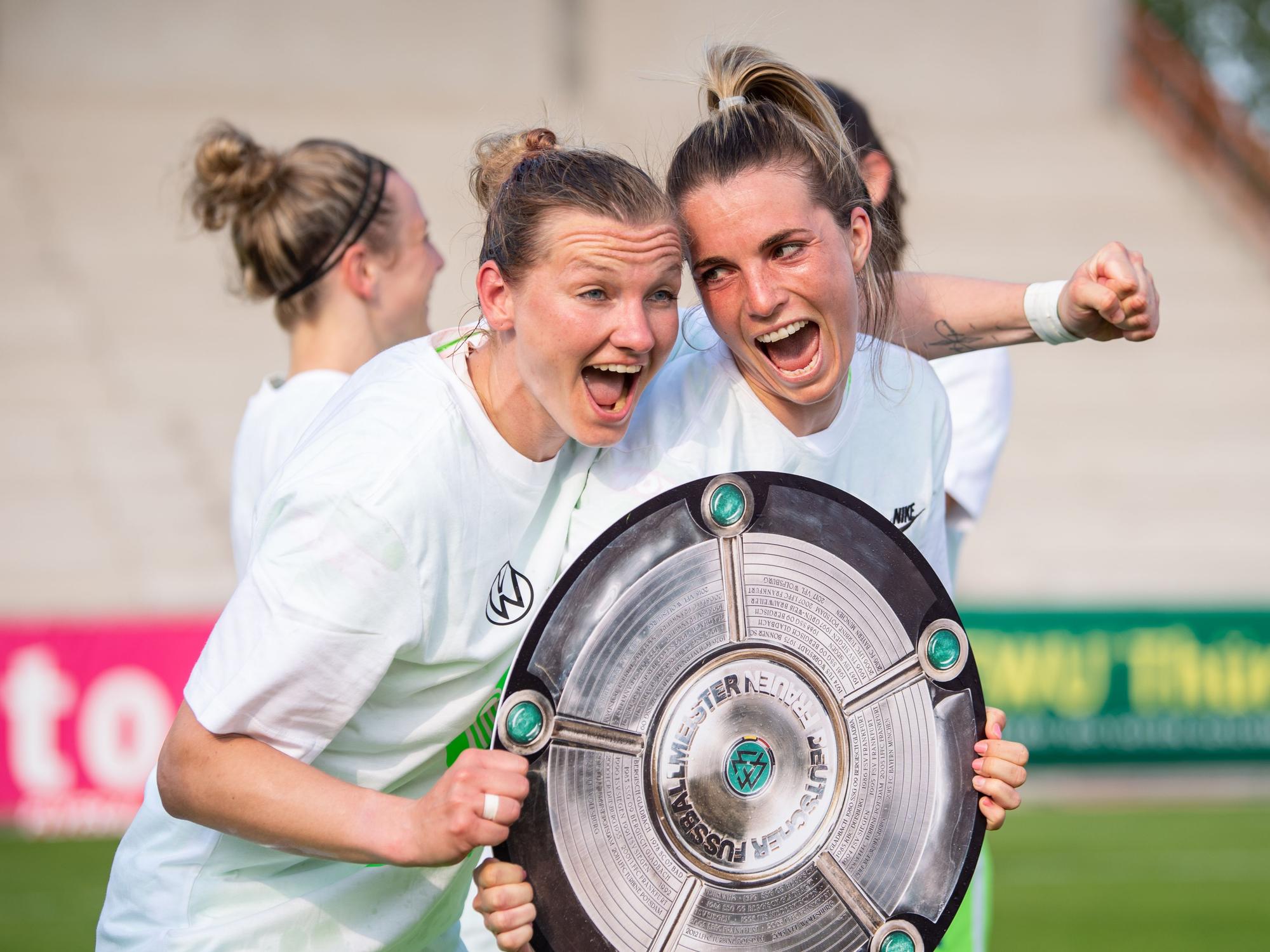 Wolfsburgs Alexandra Popp (l) und Wolfsburgs Sandra Starke halten nach dem Spiel eine Nachbildung der Meisterschale in der Hand und feiern die Deutsche Meisterschaft.