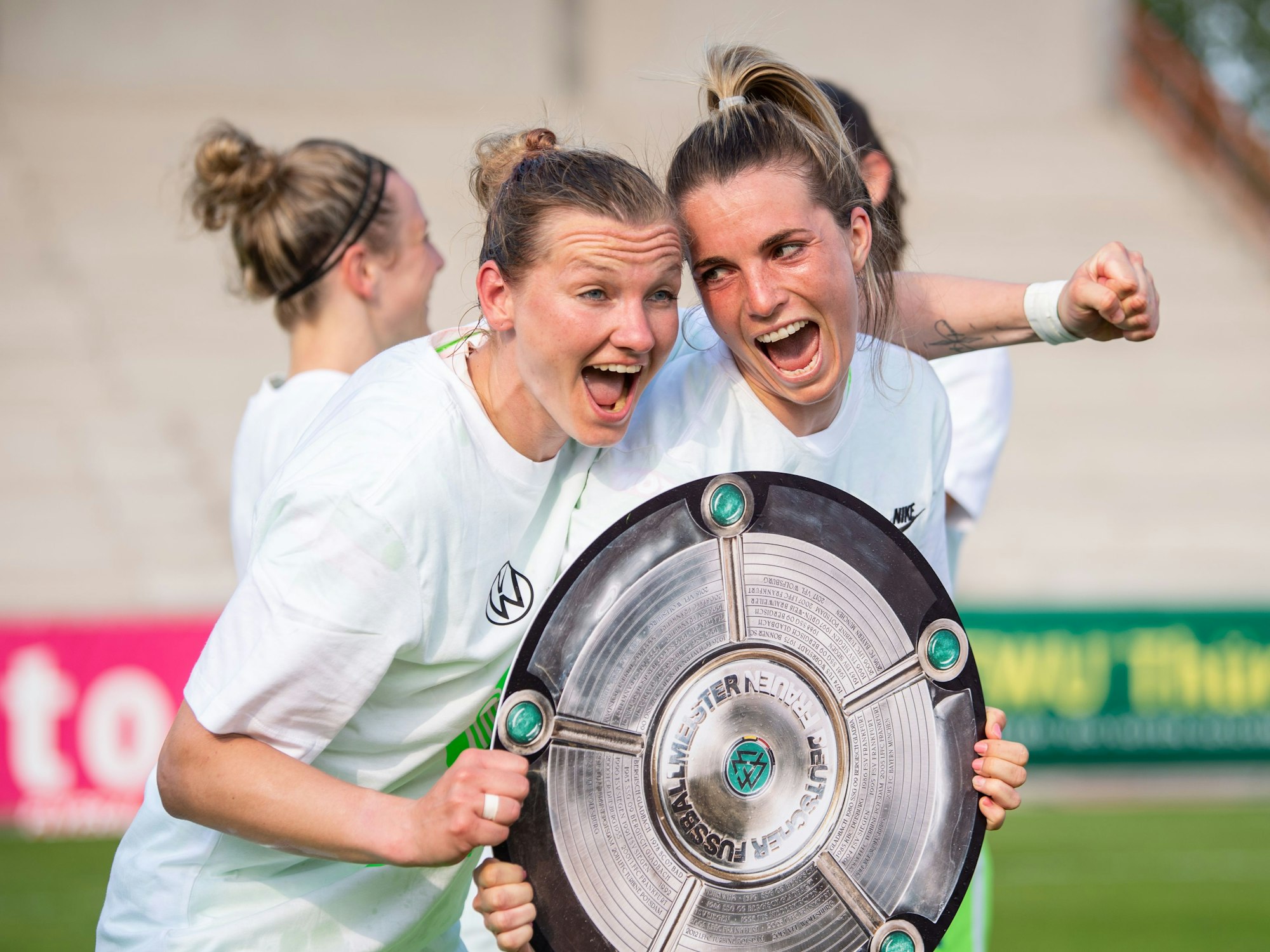 Wolfsburgs Alexandra Popp (l) und Wolfsburgs Sandra Starke halten nach dem Spiel eine Nachbildung der Meisterschale in der Hand und feiern die Deutsche Meisterschaft.