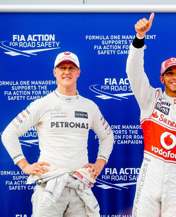 Michael Schumacher (l), damaliger Fahrer für das Team Mercedes AMG, und der Brite Lewis Hamilton, damaliger Fahrer für McLaren Mercedes, stehen nach einem Qualifying in der Formel-1 nebeneinander.