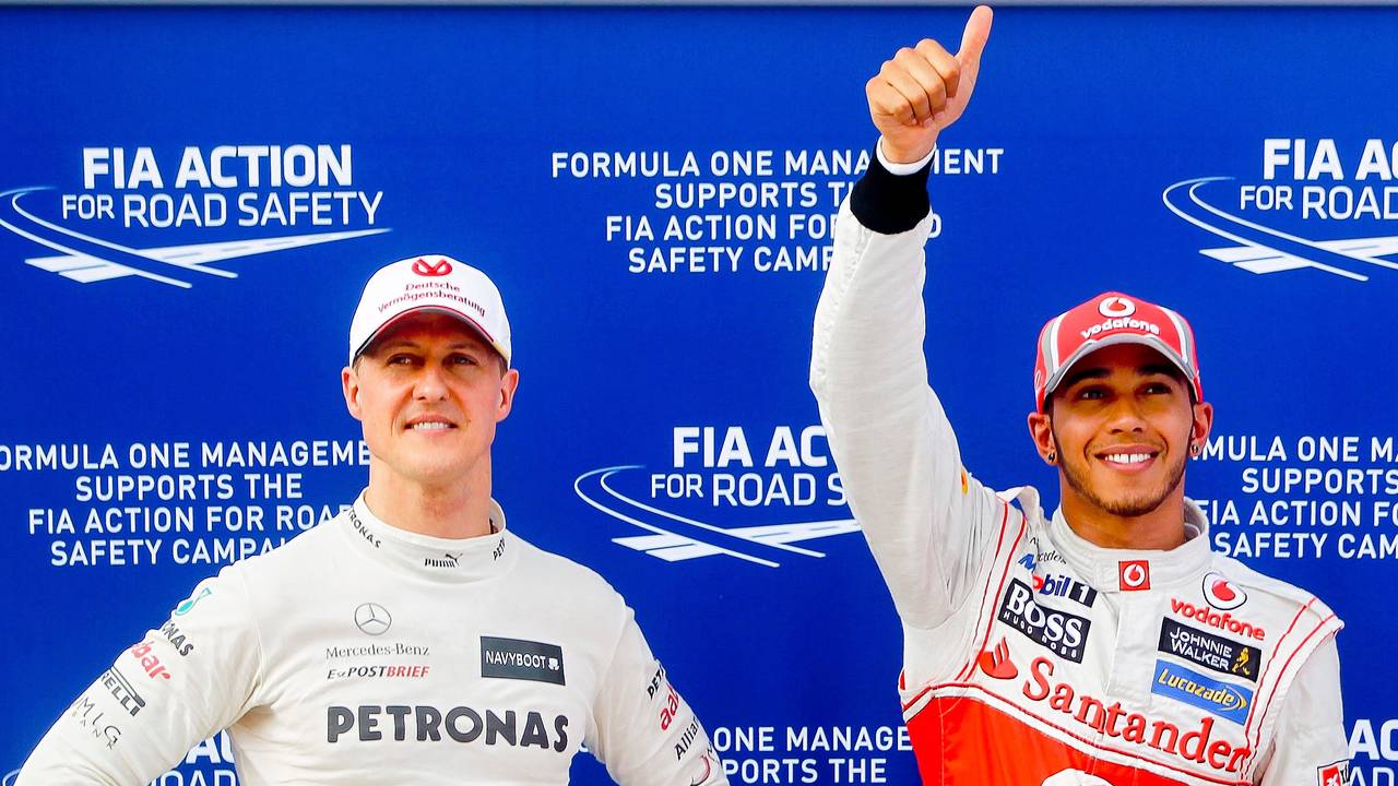 Michael Schumacher (l), damaliger Fahrer für das Team Mercedes AMG, und der Brite Lewis Hamilton, damaliger Fahrer für McLaren Mercedes, stehen nach einem Qualifying in der Formel-1 nebeneinander.