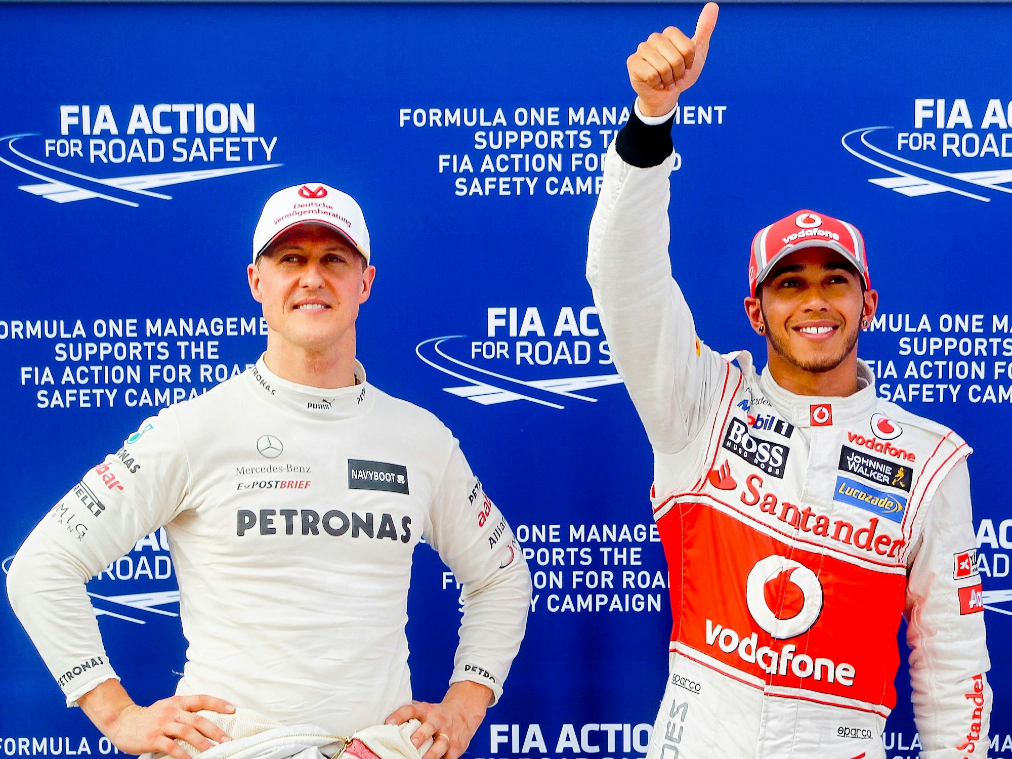 Michael Schumacher (l), damaliger Fahrer für das Team Mercedes AMG, und der Brite Lewis Hamilton, damaliger Fahrer für McLaren Mercedes, stehen nach einem Qualifying in der Formel-1 nebeneinander.