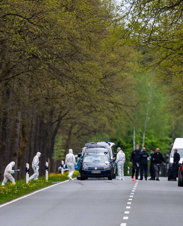 Polizei und Spurensicherung an einem Tatort in einem Wald.