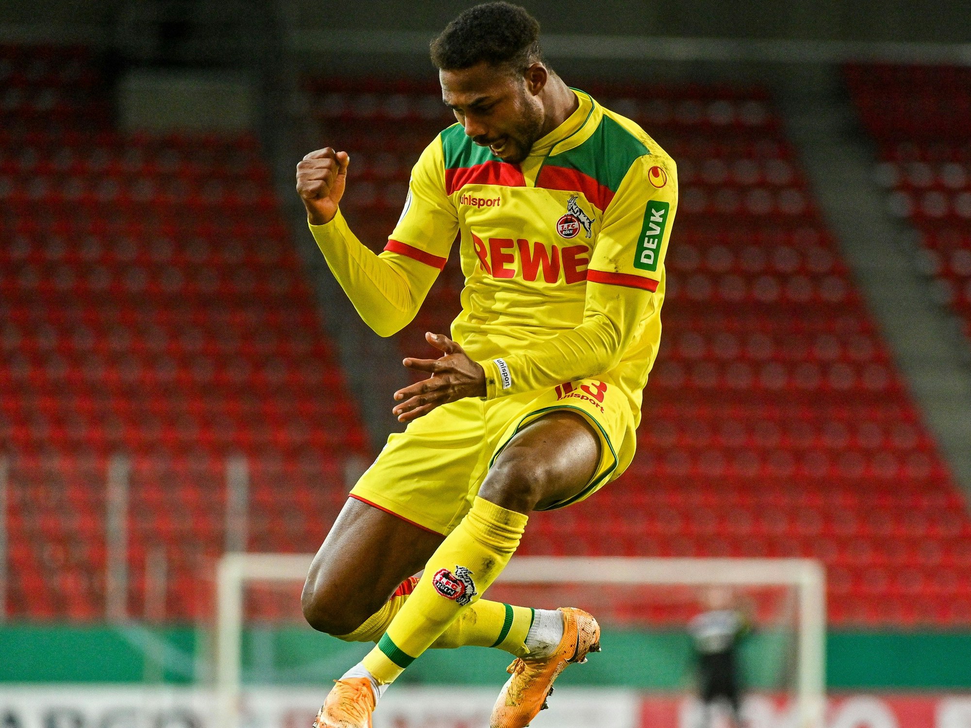 Emmanuel Dennis im gelben Trikot des 1. FC Köln bejubelt seinen Treffer.