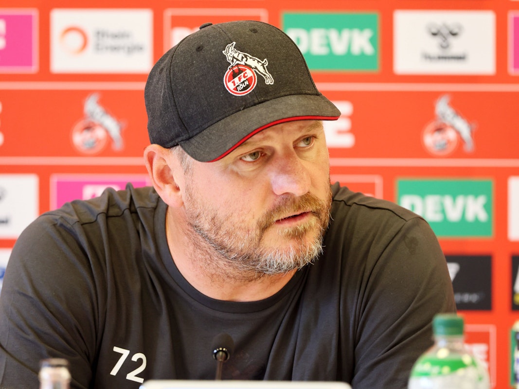 Steffen Baumgart mit FC-Cap auf der Pressekonferenz.