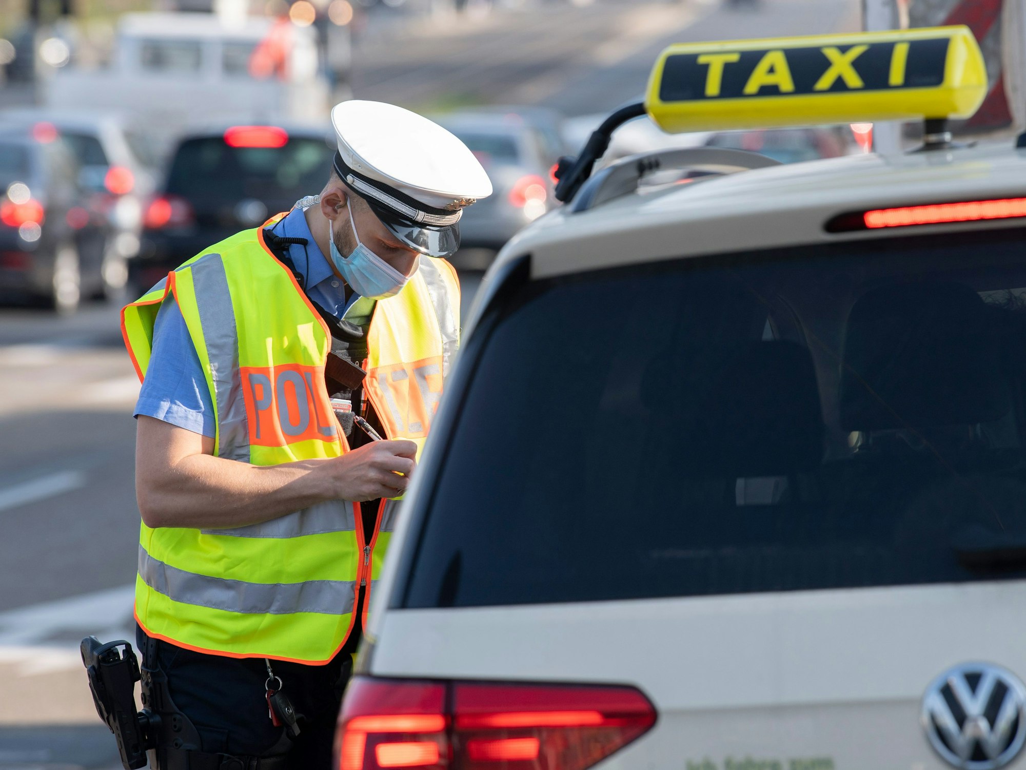 Ein Polizist kontrolliert in Darmstadt einen Taxifahrer.